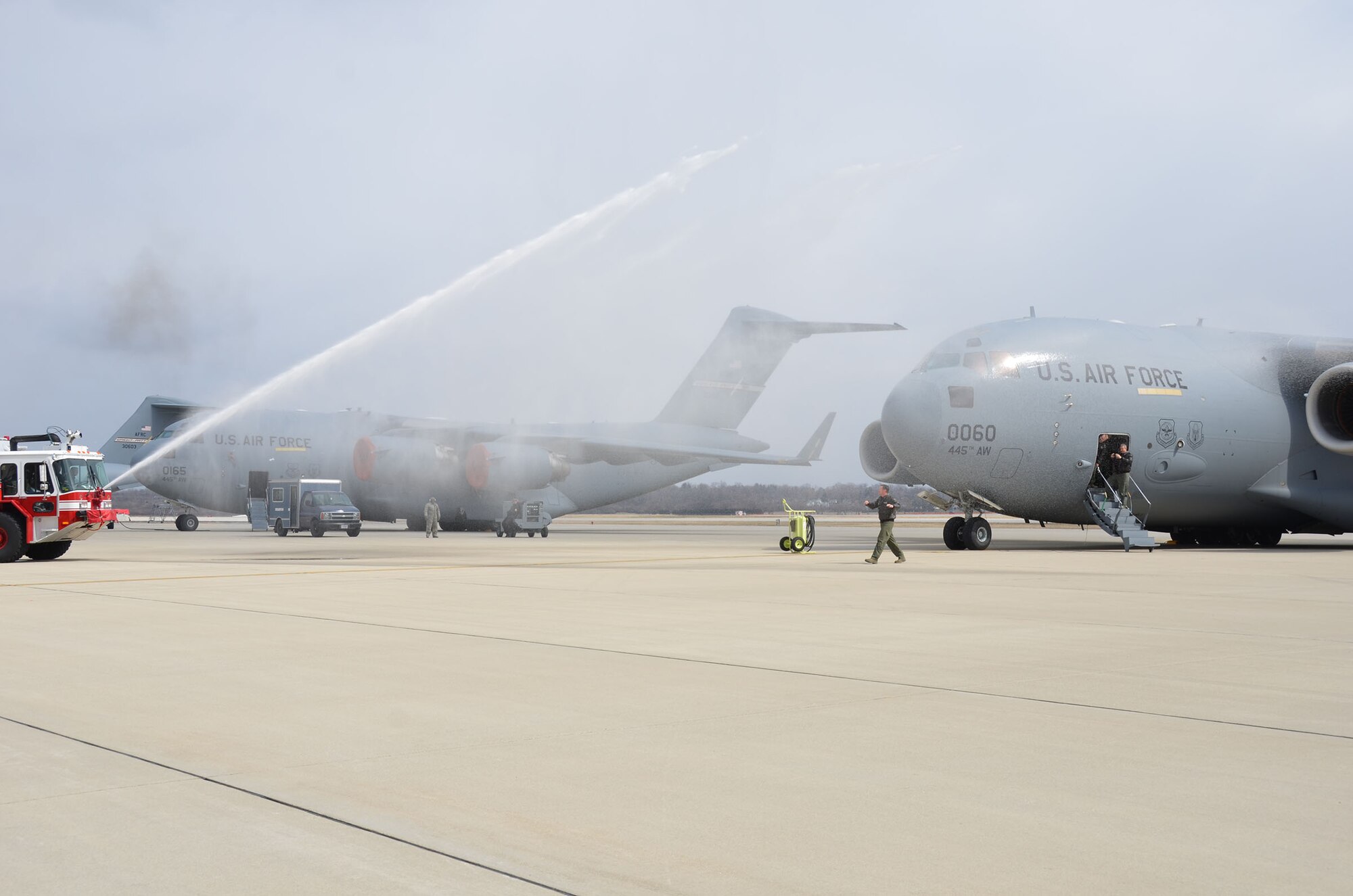 WRIGHT-PATTERSON AIR FORCE BASE, Ohio – A Wright-Patt fire truck sprays water toward a C-17 Globemaster III as Col. Kenneth Council, 445th Operations Group commander, deplanes while celebrating his final C-17 flight, or “fini flight,” here March 21. A fini flight is a time-honored military aviation tradition marking the end of a pilot’s or commander’s time upon completion of their final flight. (U.S. Air Force photo/Stacy Vaughn)