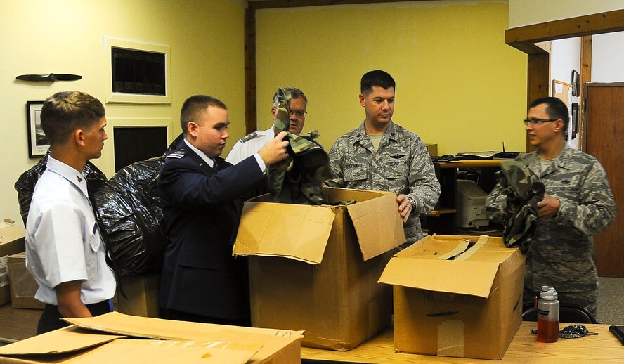 Members of the Civil Air Patrol MacDill Aviation Cadet Squadron sort through boxes of uniform donations they received at MacDill Air Force Base, Fla. March 12, 2013. They were presented with 50 woodland style BDUs by Col. Douglas Schwartz, 927th Air Refueling Wing commander here. (U.S. Air Force photo by Airman 1st Class Vernon Fowler/Released)