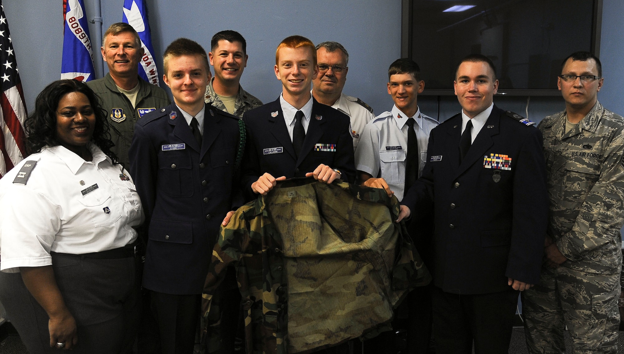 Colonel Douglas Schwartz, 927th Air Refueling Wing commander, poses with members of the Civil Air Patrol MacDill Aviation Cadet Squadron at MacDill Air Force Base, March 12, 2013. Col. Schwartz presented the cadets 50 sets of woodland style BDUs as a donation. (U.S. Air Force photo by Airman 1st Class Vernon Fowler/Released)