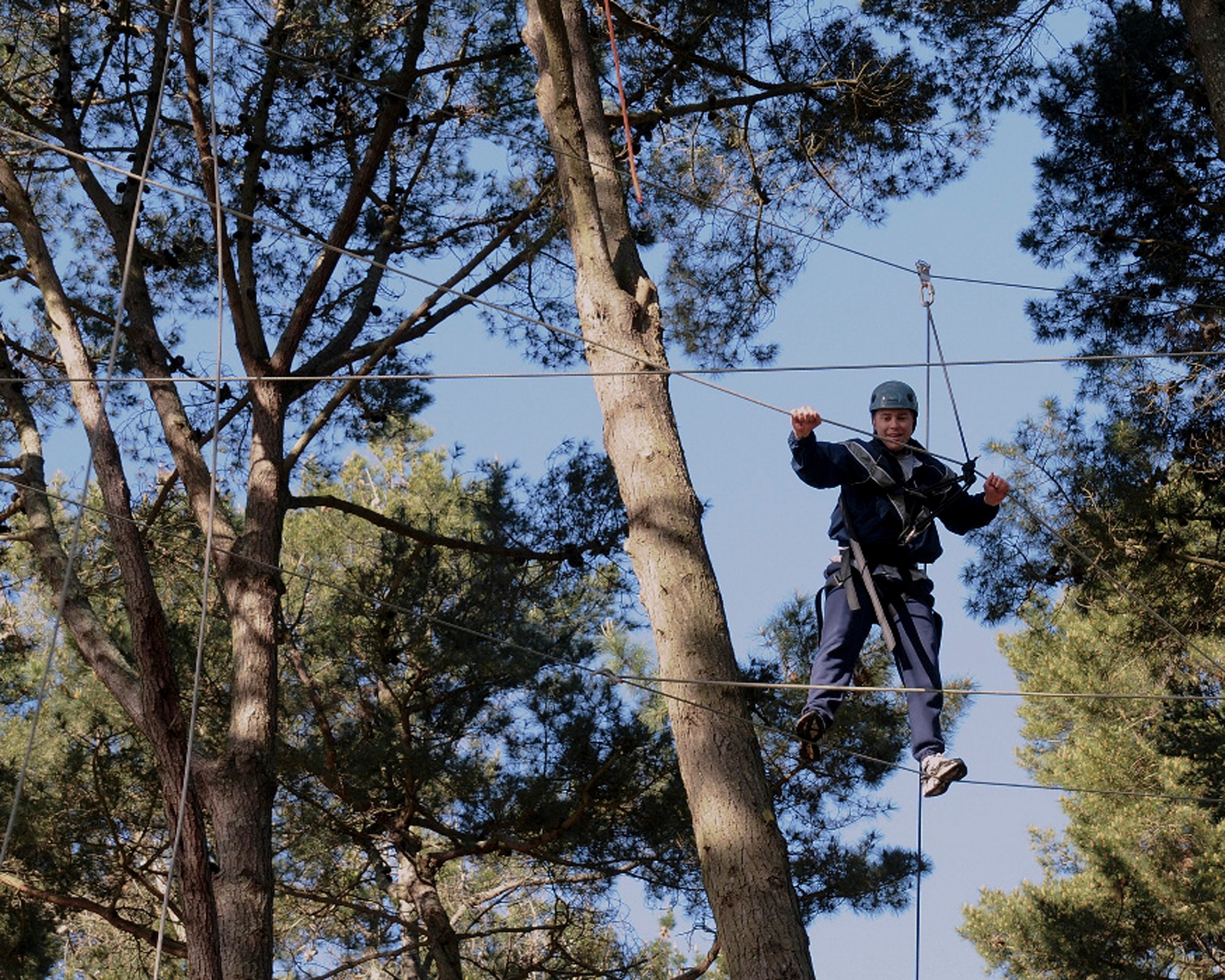 Master Sgt. Kevin Wallace, 366th Fighter Wing Public Affairs superintendent, makes his way across a tight rope, 30 feet in the air at Coast Guard Training Center Petaluma, Calif., March 8, 2013. Wallace and his ‘shipmates’ of Class 193 spent an entire day of their final week at Chief Petty Officer Academy more than 30 feet in the air, walking wires and logs, climbing enormous Redwood trees, and even scaling a telephone pole, then jumping off to grab ahold of a swinging trapeze bar about 10 feet away. (U.S. Air Force photo/Chief Petty Officer Jamie Walker)