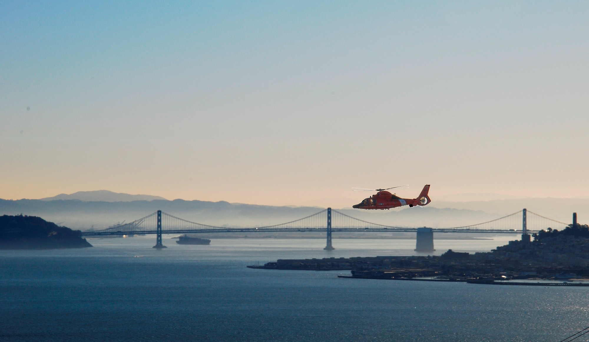 A Coast Guard HH-65C Dolphin helicopter flies near Alcatraz Island as it patrols the San Francisco Bay area Feb. 15, 2013, while Class 193 at Coast Guard Training Center Petaluma, Calif., briefed presentations on their assigned batteries at Fort Barry. Search and rescue is a major Coast Guard mission, as is drug and illegal immigration interdiction, rescuing and ice breaking operations. (U.S. Air Force photo/Master Sgt. Kevin Wallace)