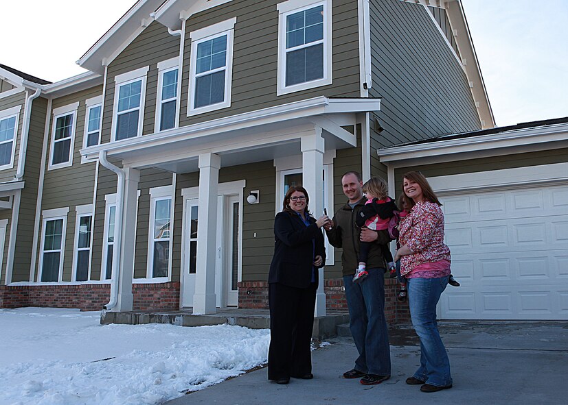 Staff Sgt. Eric Houghton, Air Force Global Strike Command, poses March 13 with his family and Mary Ann Schwalbendorf, Balfour Beatty Communities resident specialist, in front of his new base house. Houghton was the first Airman to move into one of the new houses BBC built on F. E. Warren. (U.S. Air Force photo by Matt Bilden)