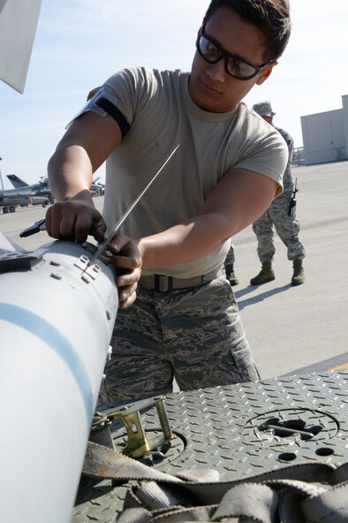 Airman 1st Class Isai Vazquez, an Aircraft Armament Systems Specialists from the 144th Aircraft Maintenance Squadron, prepares an AIM-9M missile for an F-16C Fighting Falcon while participating in a Phase I Operational Readiness Exercise March 2, 2013. The Phase I exercise tests the base's ability to transition from peacetime readiness into a wartime posture.  (Air National Guard photo by Tech. Sgt. Charles Vaughn)