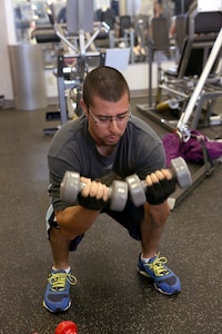 Brian Juarez, a civilian air conditioning mechanic with the 802nd Civil Engineer Squadron, does squatted bicep curls during an Intense Circuit Training class at the Gateway Fitness Center on Joint Base San Antonio-Lackland. (U.S. Air Force photo by Robbin Cresswell/Released)