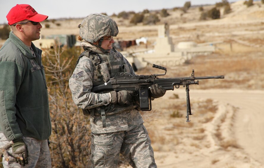 Tech. Sgt. Steven Howell, 302nd Security Forces Squadron combat arms instructor, keeps a close eye on fire team member Senior Airman Nicolina Villani-Martinez, 302nd SFS, ensuring she follows proper safety procedures while firing the M249 machine gun. The 302nd SFS spent the February Unit Training Assembly completing their annual training on heavy arms Feb. 10 at Airburst Range, Fort Carson, Colo. (U.S. Air Force photo/Staff Sgt. Nathan Federico)