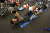 Brian Juarez, a civilian air conditioning mechanic with the 802nd Civil Engineer Squadron, works on the flutter kick with medicine ball during the Intense Circuit Training class at the Gateway Fitness Center on Joint Base San Antonio-Lackland. (U.S. Air Force photo by Robbin Cresswell/Released)