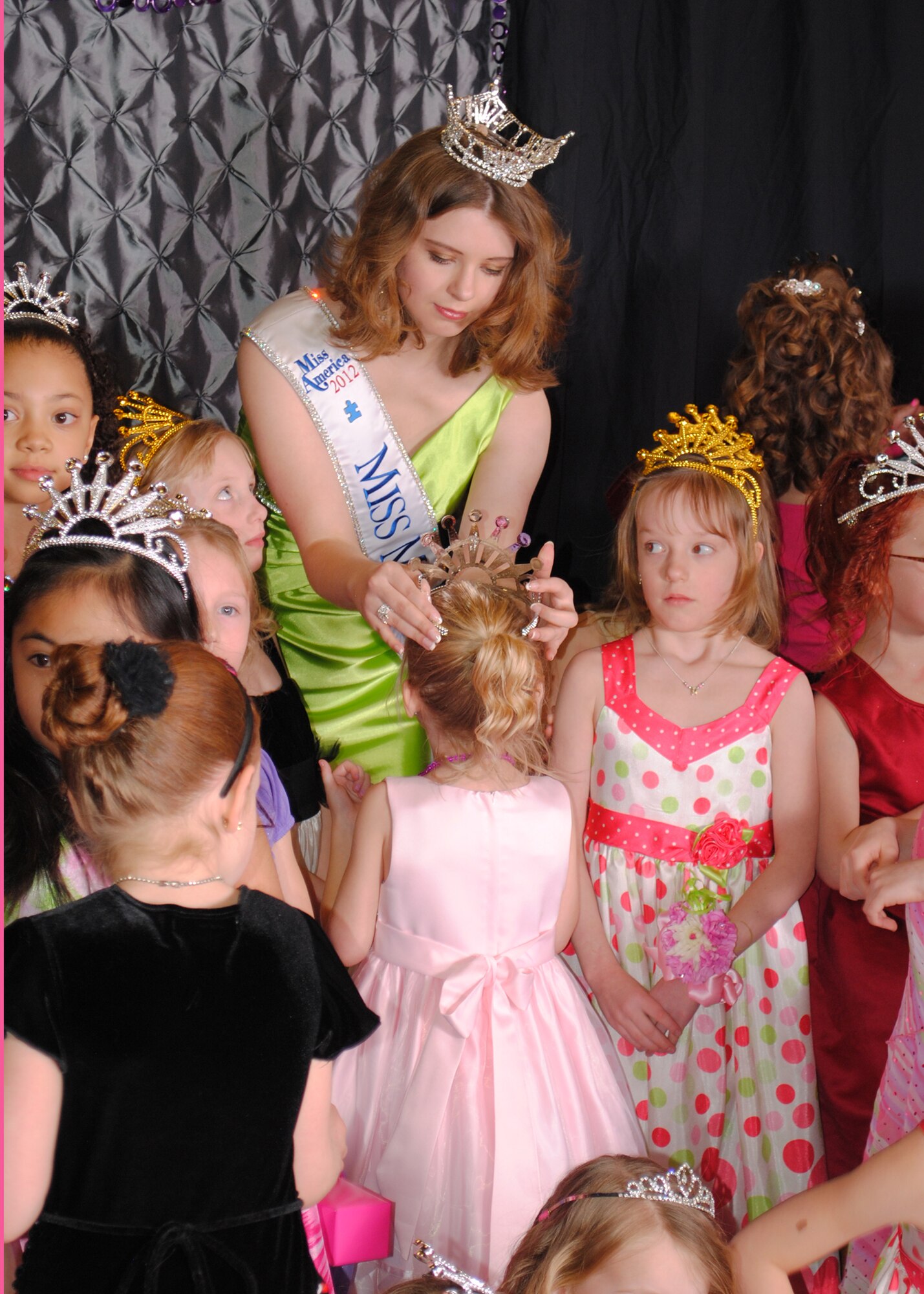 Miss Montana, Alexis Wineman, helps Kaylee; daughter of Staff Sgt. Andrew Deadmond, 341st Logistics Readiness Squadron member; put on her tiara before getting her photo taken at the Father and Daughter Dance on March 15.  The dance, set up and run by volunteers with the 341st Civil Engineer Squadron and 341st LRS, featured a dance floor, trivia game and a free box of goodies for the participants.  (U.S. Air Force photo/Senior Airman Cortney Paxton)