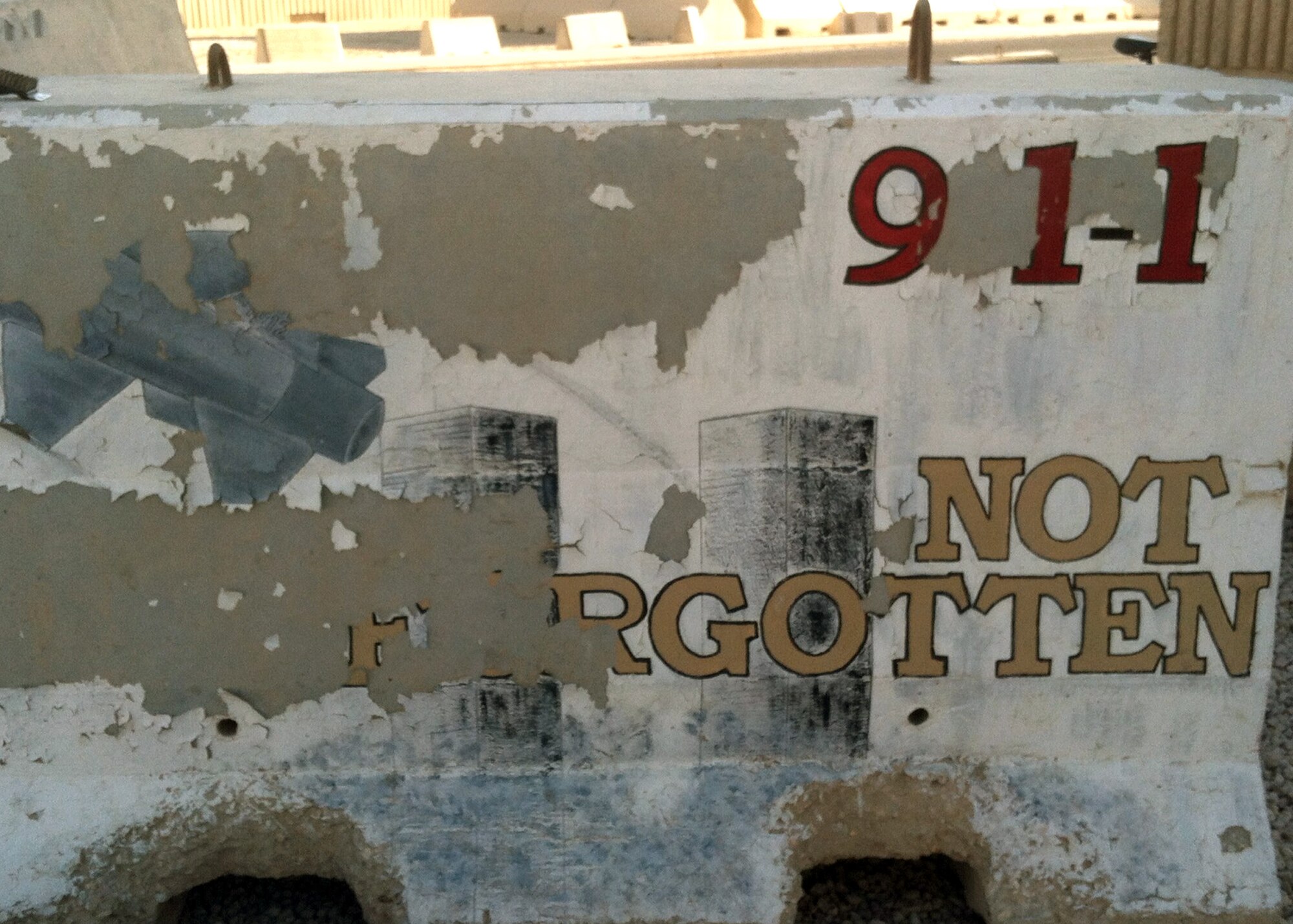 SOUTHWEST ASIA – Chipped and faded, the irony of “Not Forgotten” emblazoned on the 9/11 memorial barrier was unacceptable to the Rising 6, who adopted the memorial and asked Senior Airman Adrianna Recine, 379th Expeditionary Medical Group medical laboratory technician, to refurbish the memorial. Recine’s goal is to capture the original artist’s intent, while adding a little of her artistic style. (U.S. Air Force photo/Senior Airman Adrianna Recine)