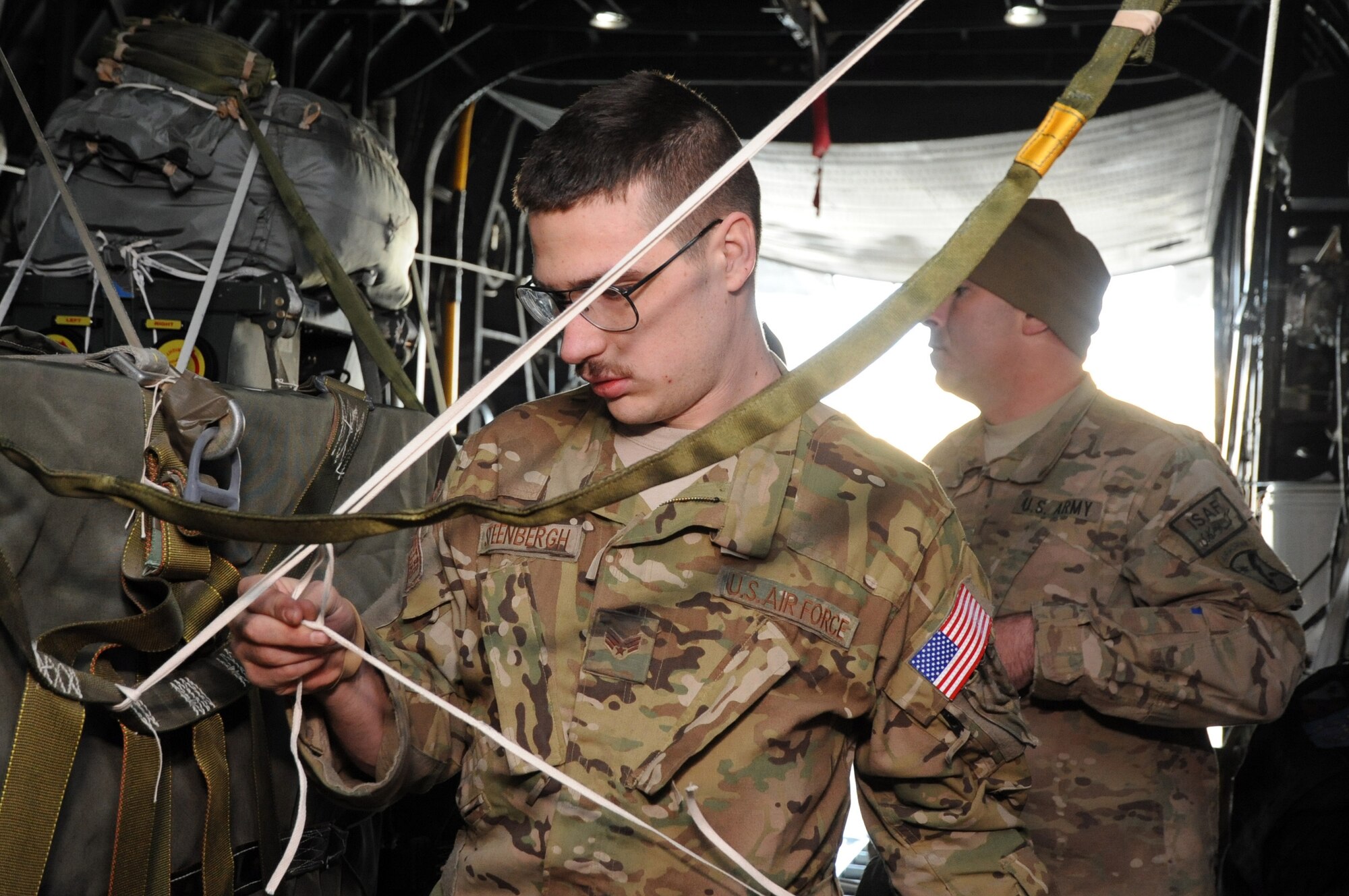 Senior Airman Adrian Steenbergh, 774th Expeditionary Airlift Squadron loadmaster, secures an anti-oscillation wire on a Joint Precision Airdrop System pallet aboard a C-130 Hercules on Bagram Airfield, Afghanistan, March 21, 2013. The 774th EAS is testing a new technique expected to greatly increase the efficiency of airdrops both downrange and elsewhere. (U.S. Air Force photo/Staff Sgt. David Dobrydney)