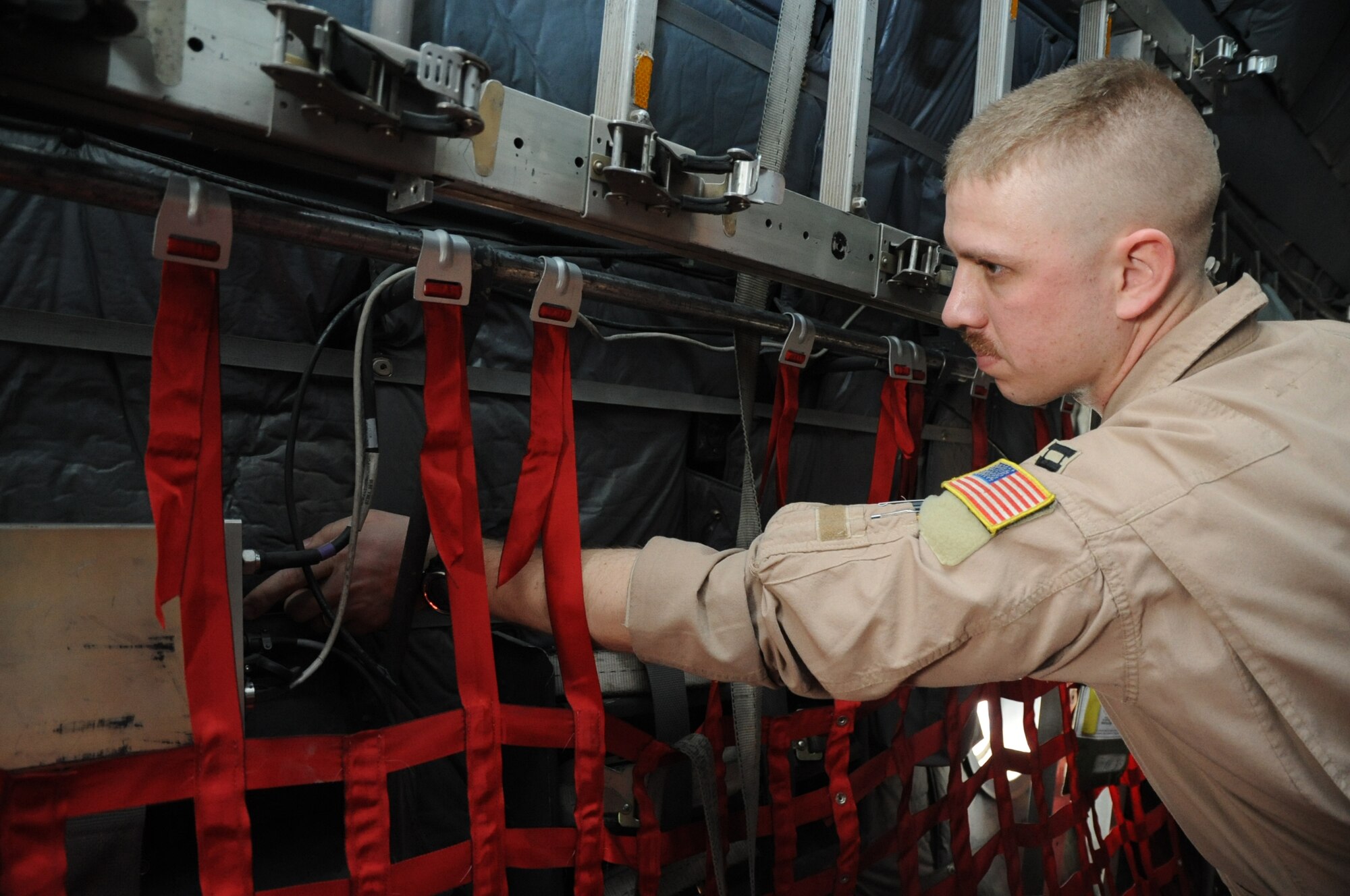 Capt. Andrew Standeford, 774th EAS precision air drop system operator, adjusts the Dropsonde Receive Subsystem during pre-flight checks aboard a C-130 Hercules aircraft on Bagram Airfield, Afghanistan, March 18, 2013. The 774th EAS recently conducted a test of the Single Pass Air Drop system, which utilizes unmanned aircraft to reduce the amount of time a cargo aircraft spends in a drop zone. (U.S. Air Force photo/Staff Sgt. David Dobrydney)