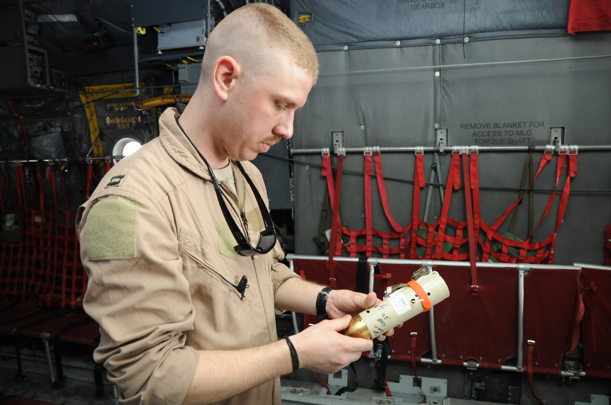 Capt. Andrew Standeford, 774th EAS precision air drop system operator, handles a drop sonde during pre-flight checks aboard a C-130 Hercules aircraft on Bagram Airfield, Afghanistan, March 18, 2013. A sonde similar to the one Standeford is holding was dropped by a unmanned aircraft as part of a test of the Single Pass Air Drop system. (U.S. Air Force photo/Staff Sgt. David Dobrydney)