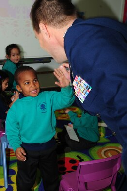 Jabari Brooks, 4, gives a high-five to Col. Christopher Kulas, 100th Air Refueling Wing commander, March 19, 2013, when the commander and his wife, Nicole, visited Great Heath Primary School in Mildenhall, England. Since many U.S. service members attend the school, Kulas was invited there. The couple toured the school and chatted with the children and staff about RAF Mildenhall and its mission (U.S. Air Force photo by Karen Abeyasekere/Released)