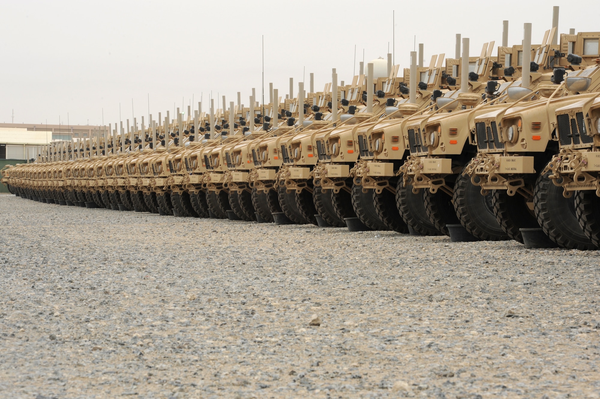 Mine-Resistant Ambush Protected vehicles wait in a staging area for onward movement at an undisclosed base in Southwest Asia Mar. 20, 2013. The joint team of soldiers, sailors, airmen and Marines of the CENTCOM Deployment & Distribution Operation Center will play a major role in moving the more than 50,000 Coalition (U.S. and NATO, of which 28,000 are U.S.) military vehicles in Afghanistan that will need to be redeployed or pre-positioned in worldwide contingency stocks abroad. (U.S. Air Force photo by Senior Master Sgt. George Thompson