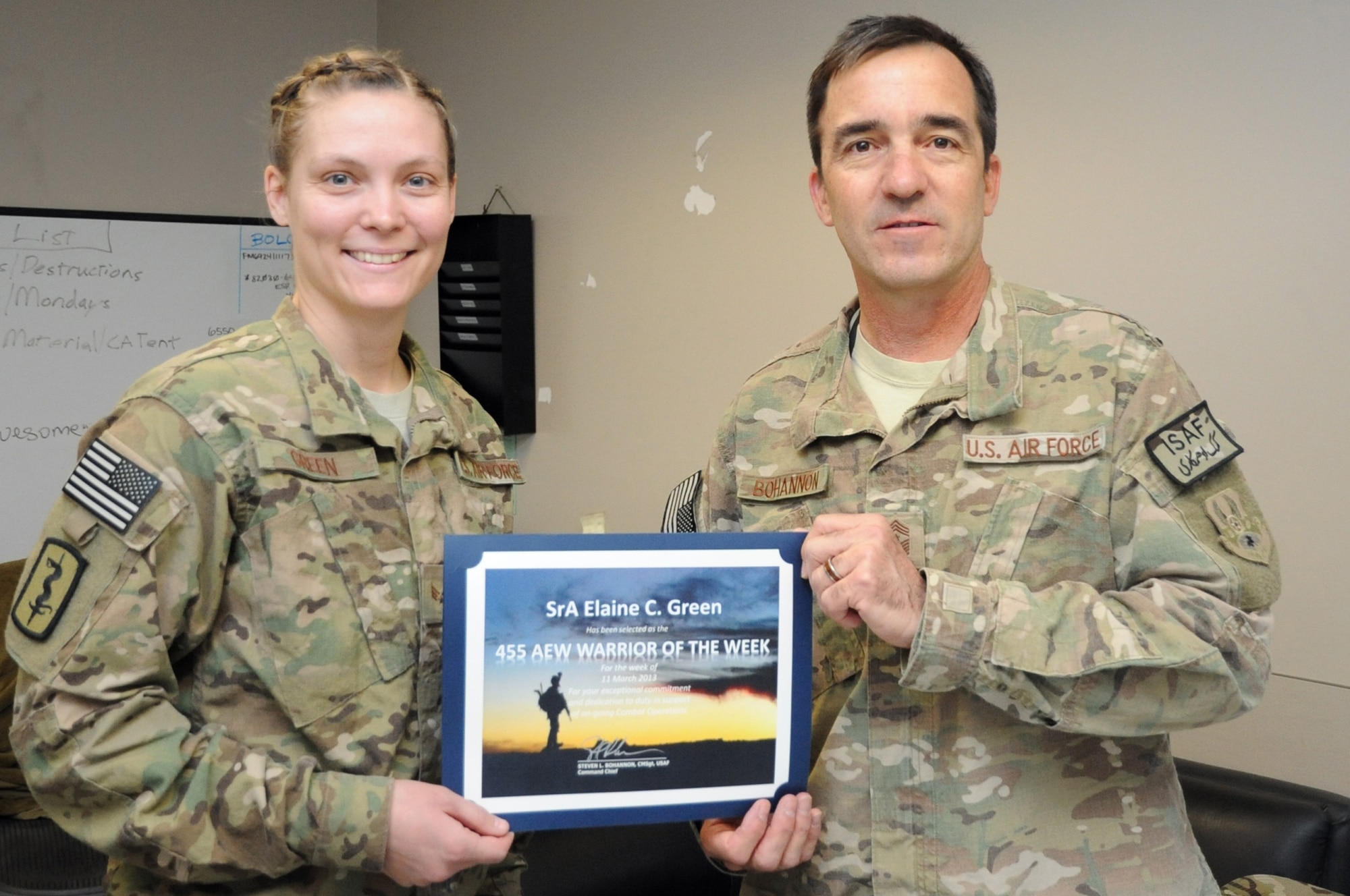 Chief Master Sgt. Steve Bohannon, Command Chief Master Sergeant of the 455th Air Expeditionary Wing, presents the "Warrior of the Week" award to Senior Airman Elaine Green, 455th Expeditionary Medical Support Squadron medical logistics technician, on Bagram Airfield, Afghanistan, March 20, 2013. Green oversees warehouse operations at the busiest trauma care hospital in Afghanistan. (U.S. Air Force photo/Staff Sgt. David Dobrydney)