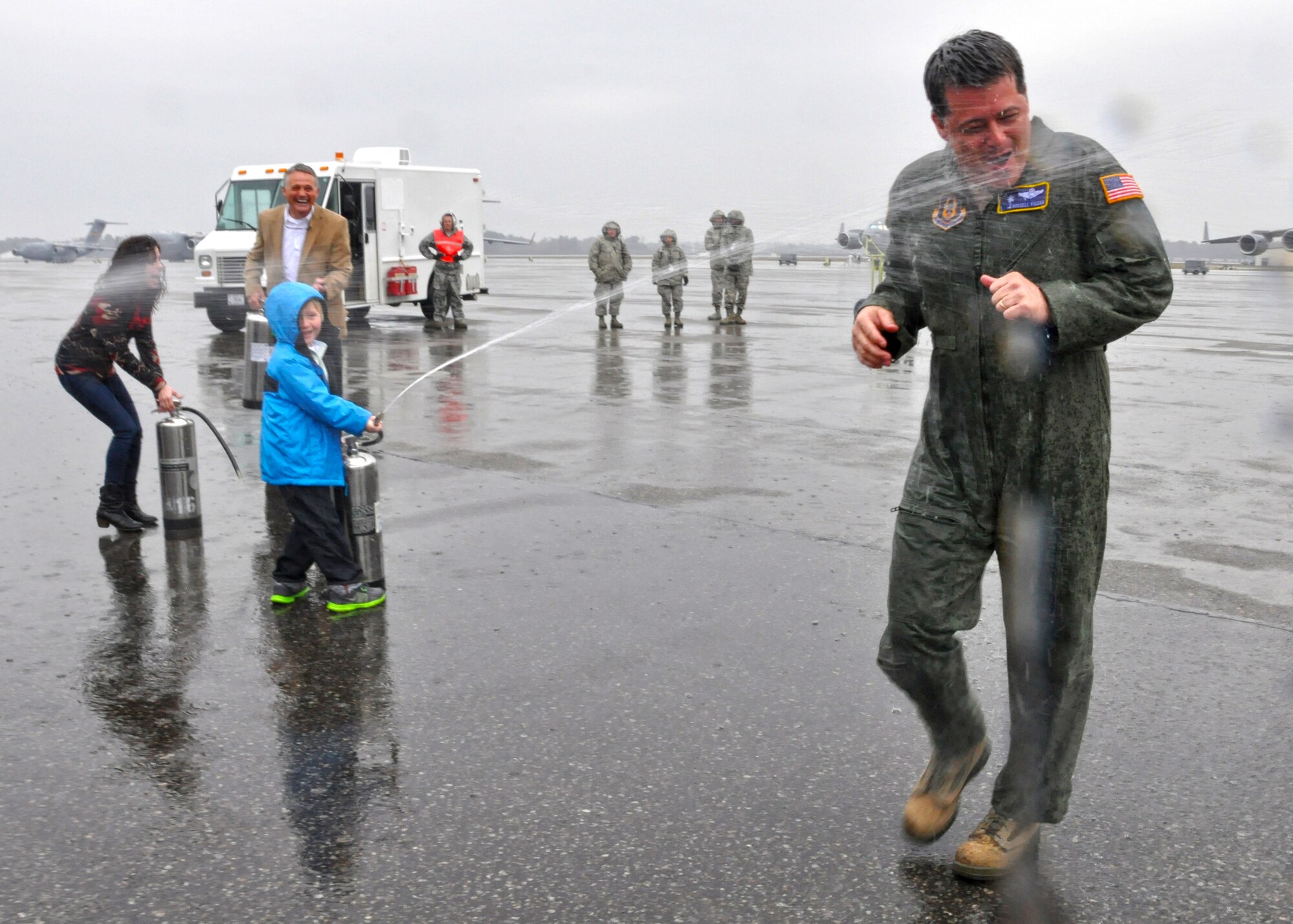 Col. Russell Fingar, 315th Airlift Wing vice commander, is sprayed by water from family and friends during his fini flight celebration March 23, 2013 at Joint Base Charleston, S.C. Fingar’s fini flight was a salute to his more than 26 years of service in the U.S. Air Force, and he will officially retire from the USAF April 01, 2013. (U.S. Air Force Photo/Staff Sgt. Shane Ellis)