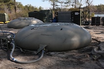 Water bladders, which can hold up to 3,000 gallons of purified water and belong to a water purification detachment from 8th Engineer Support Battalion, 2nd Marine Logistics Group, sit near Mott Lake, Fort Bragg, N.C., March 15, 2013, during the joint training exercise Rolling Thunder. The detachment used a tactical water purification system to purify water for 10th Marine Regiment, 2nd Marine Division to decrease the amount of time the regiment would need to receive drinkable water.  