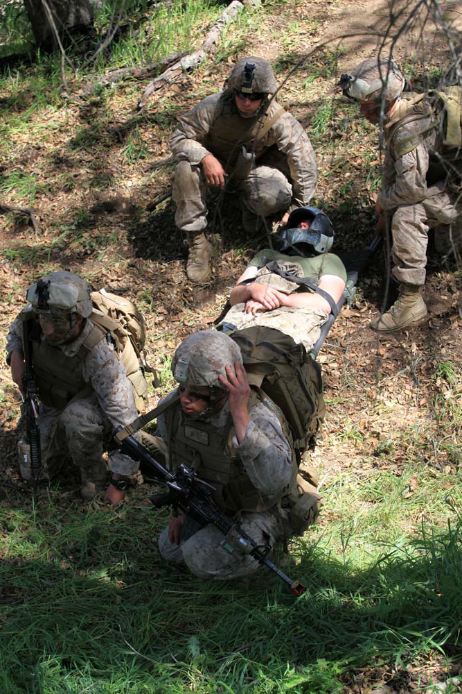 Marines with 1st Battalion, 4th Marine Regiment, 1st Marine Division, carry out an injured simulated downed pilot during Tactical Rescue of Aircraft Personnel training, at Camp Pendleton, March 21. During the TRAP mission instructors with Special Operations Training Group observed and monitored how the Marines reacted to multiple combat scenarios. The TRAP mission provides Marines with real world scenarios to prepare them for deployment.