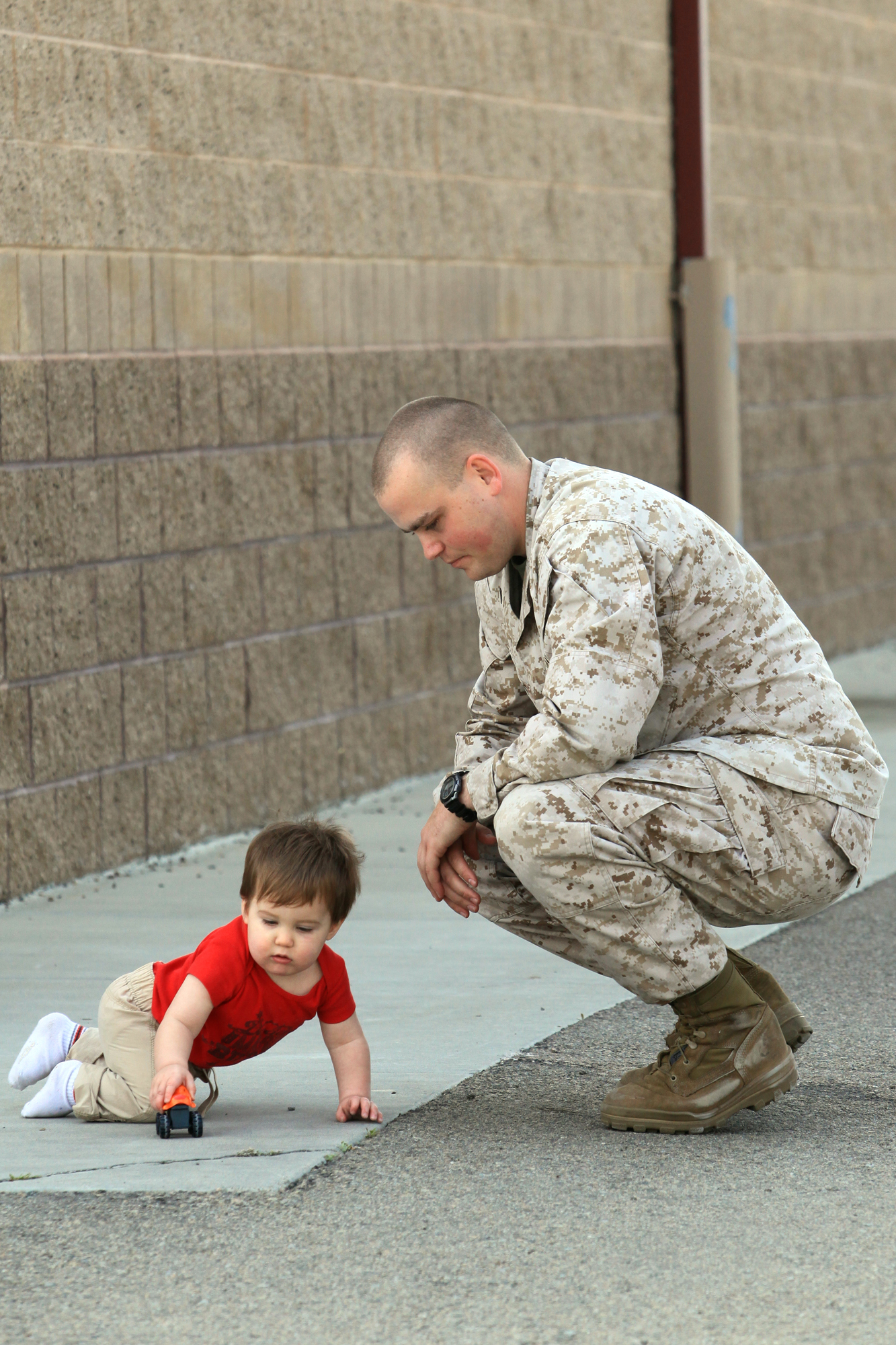A Marine with Georgian Liaison Team 8, plays with his son as he prepares to depart for a seven-month deployment to Afghanistan at Camp Pendleton, Calif., March 22. During their deployment, members from GLT 8 along with Marines from 1st Air Naval Gunfire Liaison Company will provide a link between soldiers from the Georgian Army and Marines operating in southern Afghanistan.
