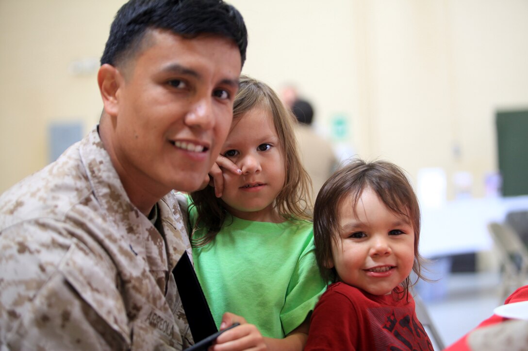 Petty Officer 2nd Class Jorge Arreola (left), a corpsman with Georgian Liaison Team 8, from Corsicana, Texas, spends time with his sons Brandon (middle) and Travis (right) before departing for a seven-month deployment to Afghanistan at Camp Pendleton, Calif., March 22. During their deployment, members from GLT 8 along with Marines from 1st Air Naval Gunfire Liaison Company will provide a link between soldiers from the Georgian Army and Marines operating in southern Afghanistan.