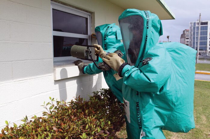 During training, 3rd Marine Logistics Group chemical, biological, radiological, and nuclear defense specialists scan the perimeter of a building March 18 at Camp Kinser. The Marines are with 3rd MLG, III Marine Expeditionary Force.