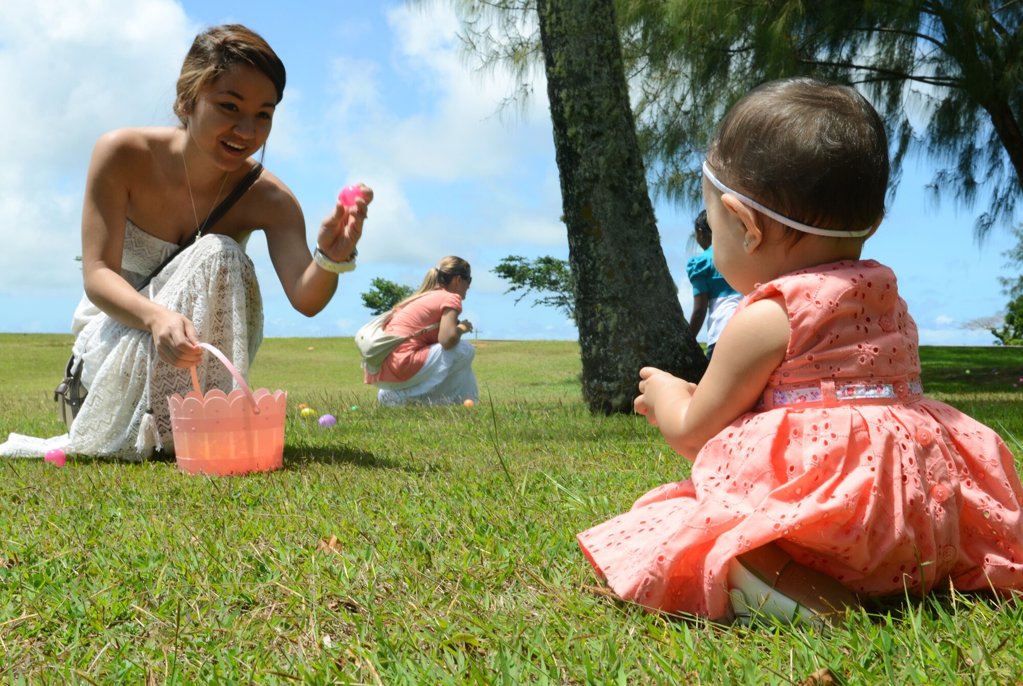 Brianna Lujan helps her daughter gather plastic eggs during the 554th RED HORSE Squadron Egg-stravaganza on Andersen Air Force, Guam, March 23, 2013. The squadron function was a combined information fair, potluck lunch and children’s Easter egg hunt planned by the unit’s spouses to help families of deployed military members celebrate the season and expose them to many of the base’s support programs. (U.S. Air Force photo by Senior Airman Benjamin Wiseman/Released)