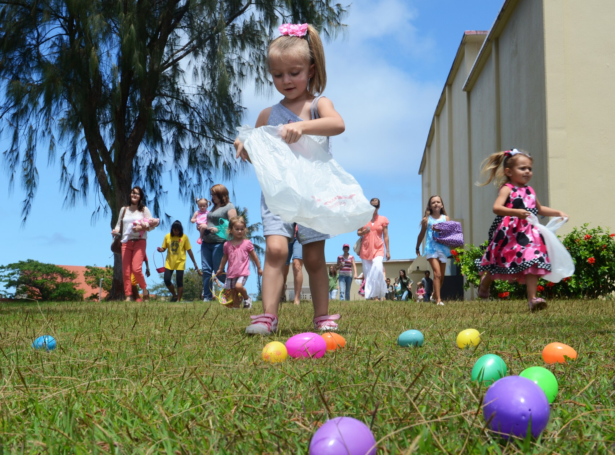 Children of 554th RED HORSE Squadron service members race to gather plastic eggs during the 554th RED HORSE Squadron Egg-stravaganza on Andersen Air Force, Guam, March 23, 2013. The squadron function was a combined information fair, potluck lunch and children’s Easter egg hunt planned by the unit’s spouses to help families of deployed military members celebrate the season and expose them to many of the base’s support programs. (U.S. Air Force photo by Senior Airman Benjamin Wiseman/Released)