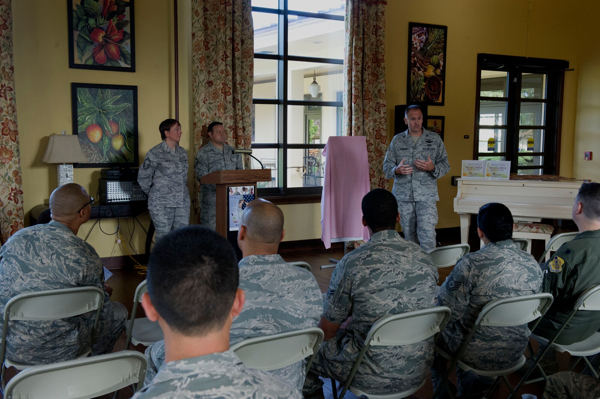 Senior Master Sgt. Michelle Rootes, 2013 Air Force Assistance Fund Installation Project Officer, (Far left) stands with Master Sgt. Jose Montoya, also a 2013 AFAF IPO, as 15th Wing Commander Col. John Roscoe addresses the campaign’s volunteers in the Ka Makani Community Center at Joint Base Pearl Harbor-Hickam, Hawaii, on March 25, 2013. The AFAF is an annual, on-the-job fundraiser conducted among Air Force personnel for the benefit of Air Force personnel. (U.S. Air Force photo/Staff Sgt. Terri Paden)