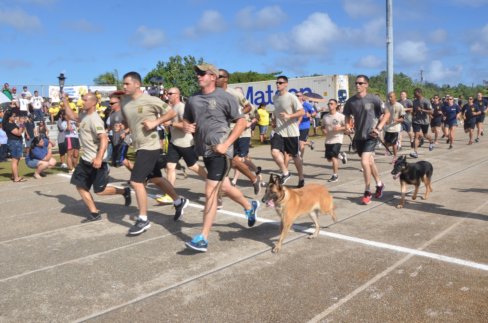 Members from the 736th Security Force Squadron run with the torch during the 37th Annual Special Olympics of Guam Track and Field event at Okkodo High School in Dededo, Guam, March 23, 2013.  More than 300 service members from all military branches came together to support Special Olympic athletes in a variety of Olympic-type sports for children and adults with intellectual disabilities, giving them continuing opportunities to develop physical fitness and demonstrate courage.  (U.S. Air Force photo/Staff Sgt. Veronica McMahon/Released)