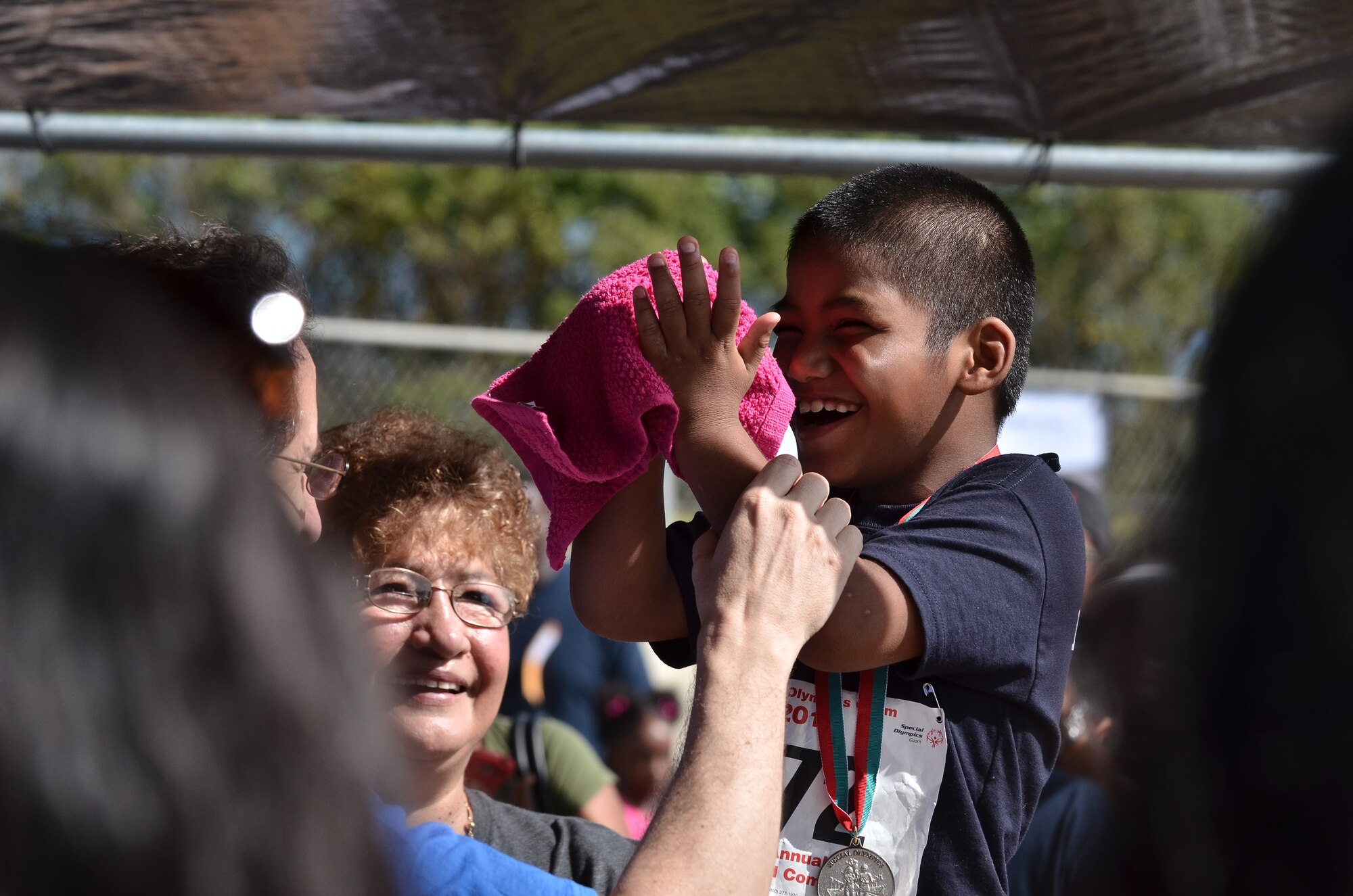 Calvin Santos, Special Olympics of Guam athlete, receives the second place medal for the shot put event during the 37th Annual Special Olympics of Guam Track and Field event at Okkodo High School in Dededo, Guam, March 23, 2013.  The Special Olympics mission is to provide year-round sports training and athletic competition in a variety of Olympic-type sports for children and adults with intellectual disabilities, giving them continuing opportunities to develop physical fitness and demonstrate courage. (U.S. Air Force photo/Staff Sgt. Alexandre Montes/Released)