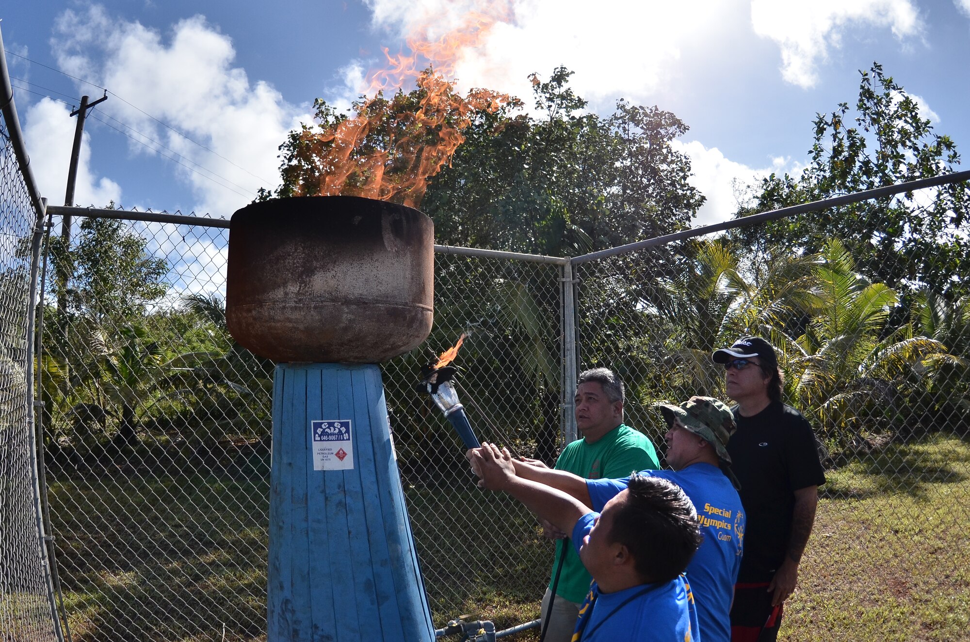 Quentin San Nicholas (left), Guam Special Olympics athlete and Carlo Leon Guerrero (right), Special Olympics volunteer, light the cauldron during the opening ceremony at the 37th Annual Special Olympics of Guam Track and Field event at Okkodo High School in Dededo, Guam, March 23, 2013.  More than 300 service members from all military branches came together to support Special Olympic athletes in a variety of Olympic-type sports for children and adults with intellectual disabilities, giving them continuing opportunities to develop physical fitness and demonstrate courage. (U.S. Air Force photo/Staff Sgt. Alexandre Montes/Released)