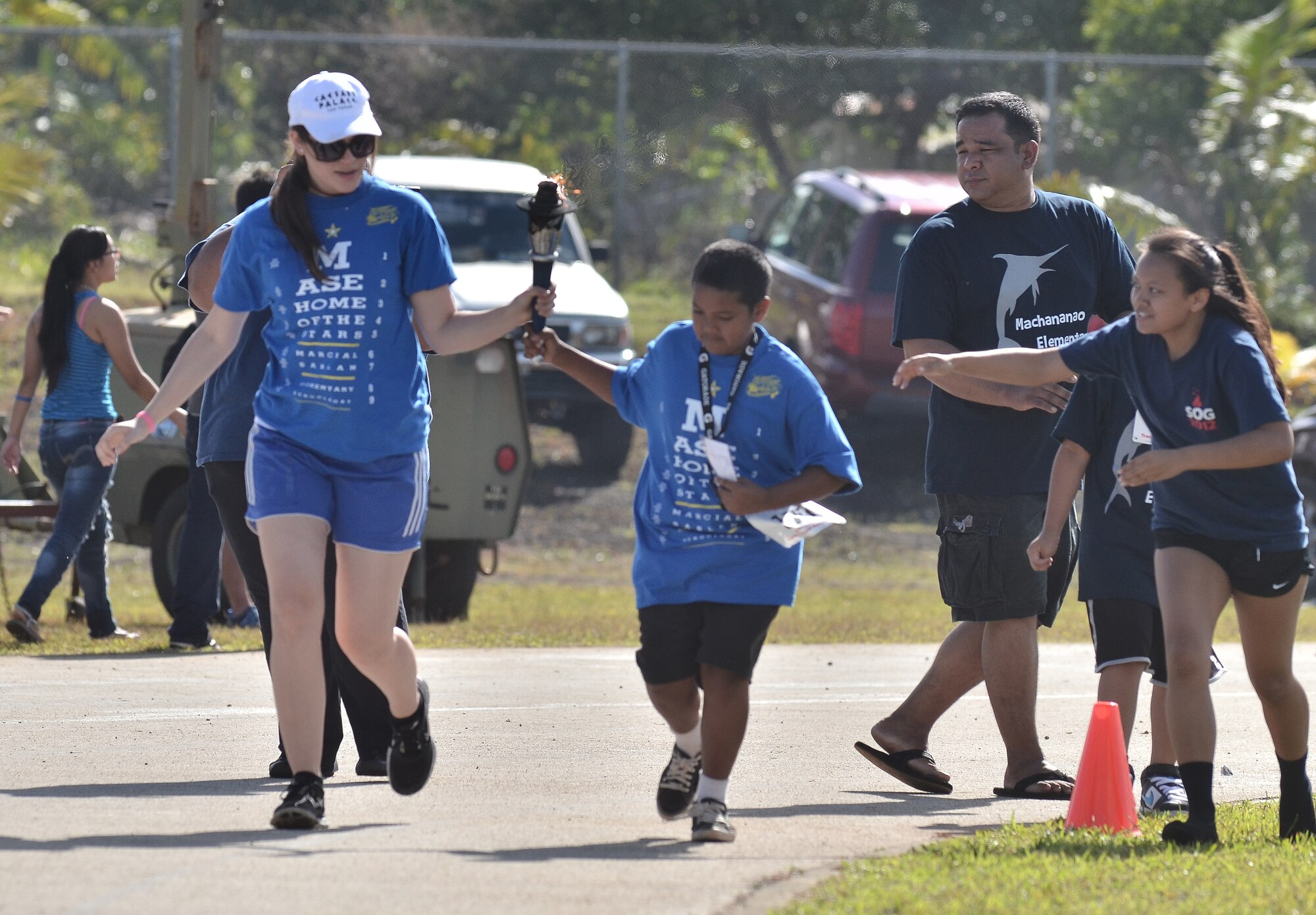 Erika Lorenzo (left), Special Olympics volunteer, helps Austin Santos (right), Guam Special Olympics athlete, run with the torch during the opening ceremony at the 37th Annual Special Olympics of Guam Track and Field event at Okkodo High School in Dededo, Guam, March 23, 2013.  The Special Olympics mission is to provide year-round sports training and athletic competition in a variety of Olympic-type sports for children and adults with intellectual disabilities, giving them continuing opportunities to develop physical fitness and demonstrate courage. (U.S. Air Force photo/Staff Sgt. Alexandre Montes/Released)