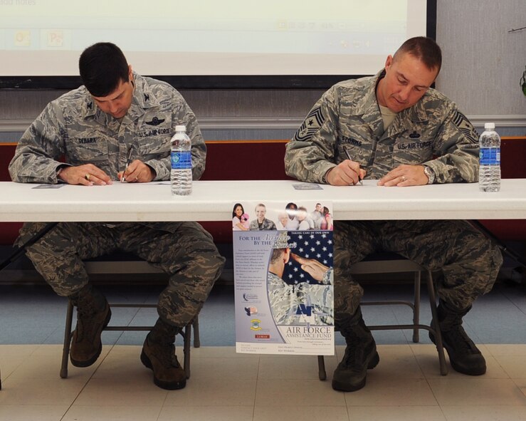 Col. Andrew Gebara, 2nd Bomb Wing commander, and Chief Master Sgt. Curtis Storms, 2nd BW command chief, make the first donations to the Air Force Assistance Fund on Barksdale Air Force Base, La., March 25. The AFAF was established to raise funds for the charitable affiliates that provide support to the Air Force family. (U.S. Air Force photo/Senior Airman Sean Martin)