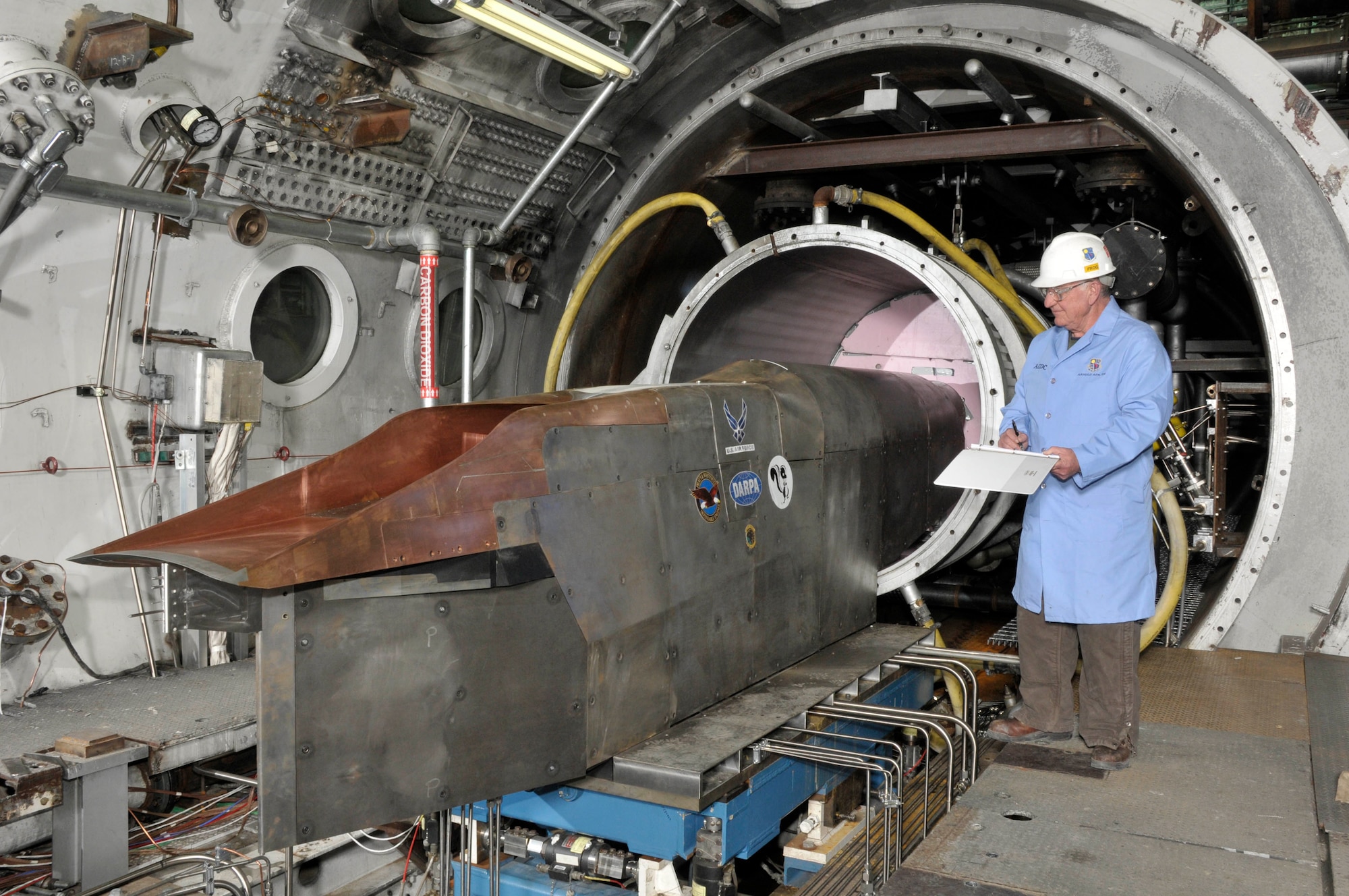 An Aerospace Testing Alliance outside machinist inspects the Defense Advanced Research Projects Agency’s Falcon Combined-cycle Engine Technology (FaCET) scramjet test article in the center’s Aerodynamic and Propulsion Test Unit test cell prior to a test. (Photo by Rick Goodfriend)