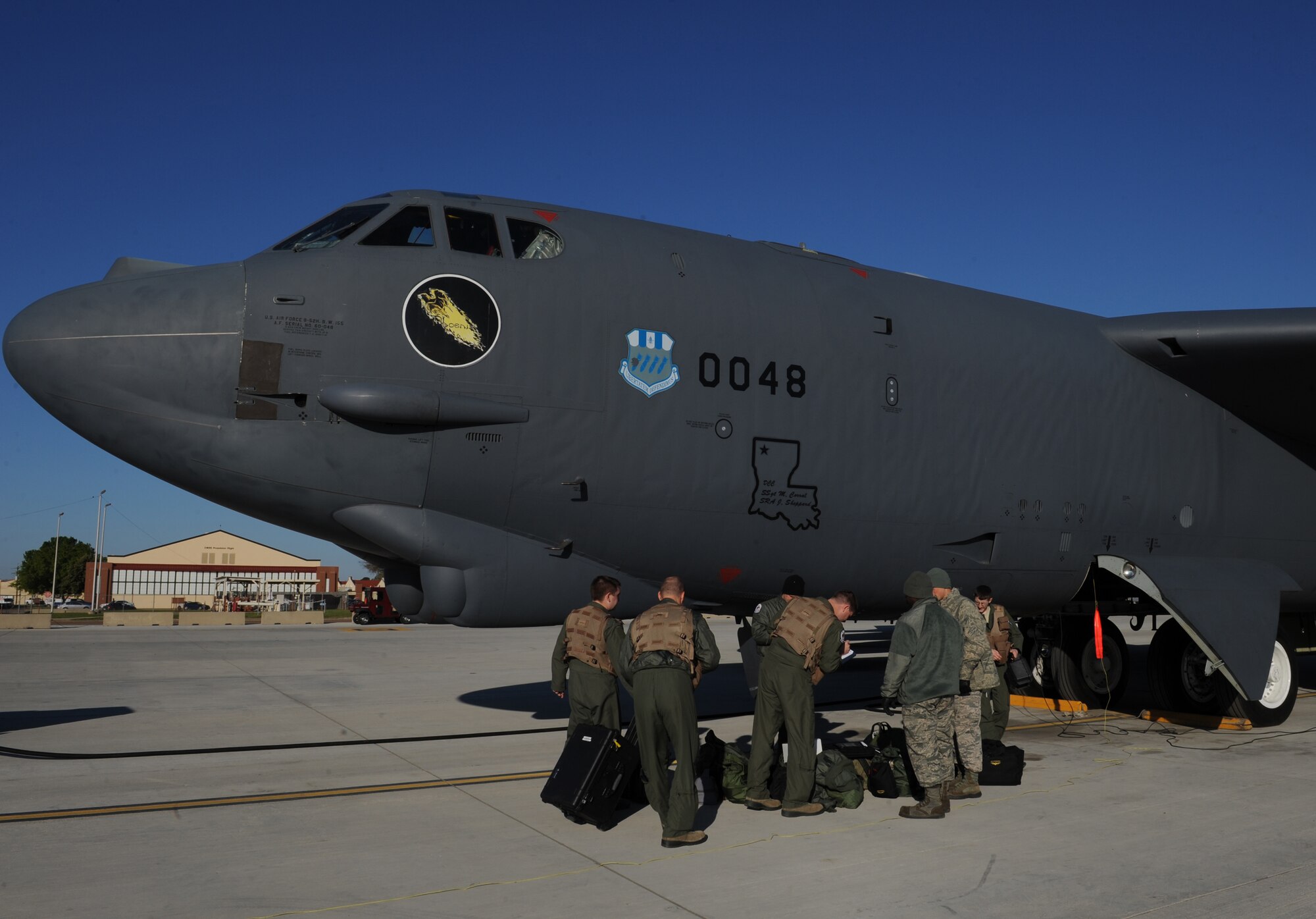 Members of the 20th Bomb Squadron place their equipment on the ground before receiving a briefing on the condition of the aircraft they'll be flying on Barksdale Air Force Base, La., March 25. At the aircraft, the aircrew discuss the type of mission they are performing, the general procedures for ground checks and starting the engines with the crew chiefs. (U.S. Air Force photo/Airman 1st Class Benjamin Gonsier)
