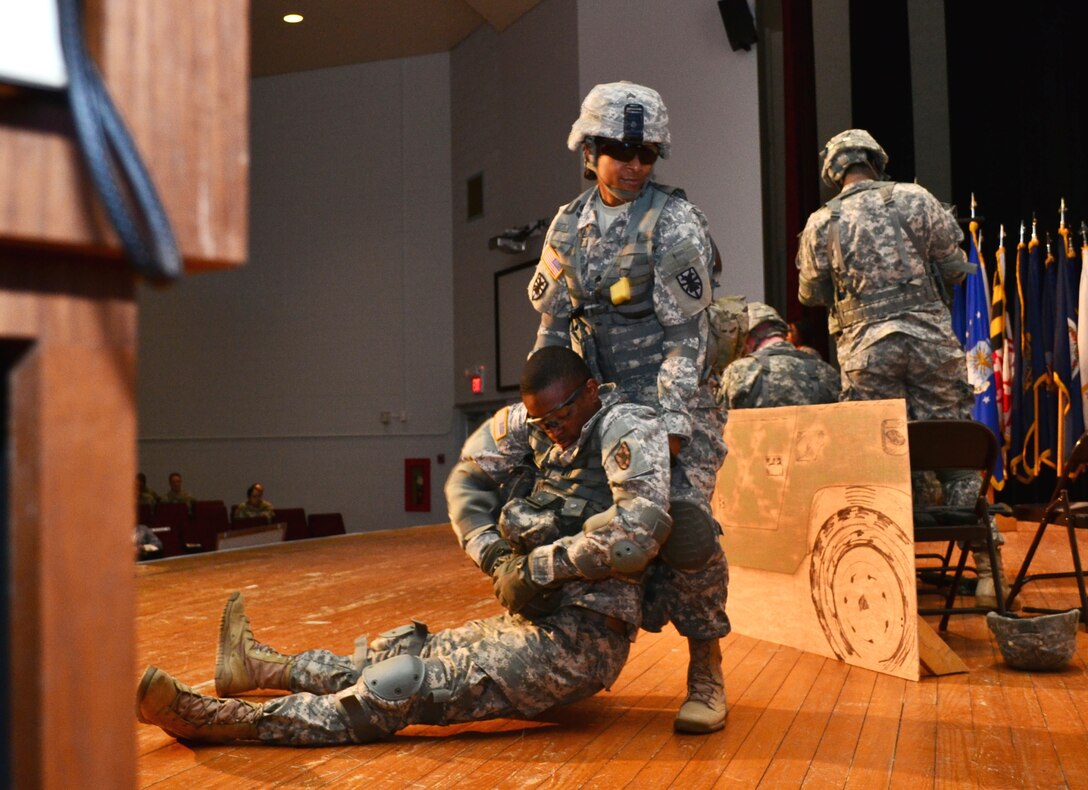 U.S. Army Sgt. Cynthia Fisher, assigned to the Special Troops Battalion, 7th Sustainment Brigade, pulls a fellow Soldier out of harm’s way during a theater representation of women in combat during the 7th Sus. Bde.’s “Women Inspiring Innovation Through Imagination” event at Jacobs Theater at Fort Eustis, Va., March 19, 2013. The observance, hosted by 7th Sus. Bde. commander Col. Jennifer Reinkober, featured rich history and highlighted the extraordinary achievements of American women. (U.S. Army photo by Sgt. Edwin Rodriguez/Released)(U.S. Army photo by Sgt. Edwin Rodriguez/Released)