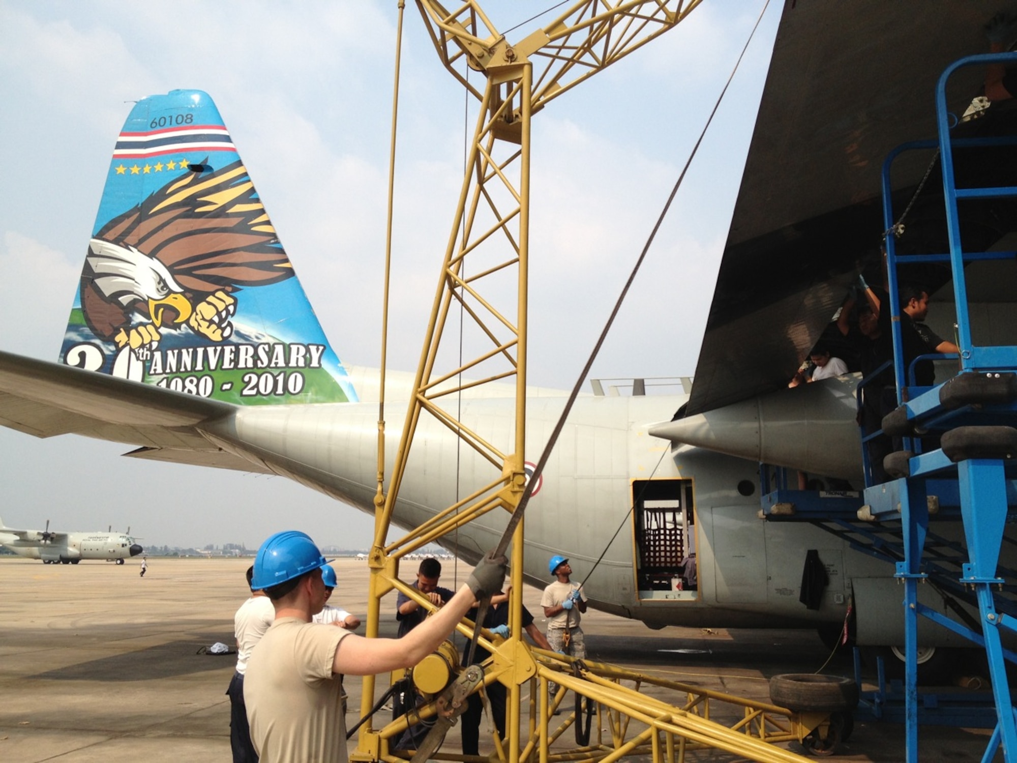 Tech. Sgt. Micheal Williamson (fore; blue helmet), and Tech. Sgt. Brandon Jackson (in ABU's closest to aircraft), both with the 373rd Training Squadron Field Training Detachment 4 from Little Rock Air Force Base, Ark., conduct training with the Royal Thai Air Force on a C-130 wing flap installation during February, 2013, at Don Muang Air Base, Thailand. The training was part of a month-long C-130 maintenance mobile training team deployment for the RTAF in Bangkok. (U.S. Air Force courtesy photo)   