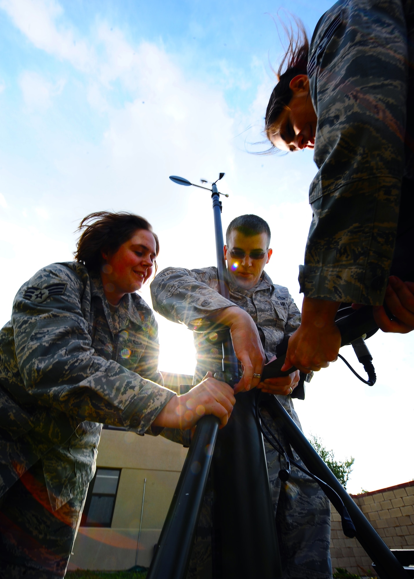 Weather forecasters from the 7th Operations Support Squadron, Senior Airman Sara Wauer (center), Senior Airman Ann Winters (right) and Staff Sgt. James Ellis (left), assemble a Tactical Meteorological Observing System (TMQ-53) near the flightline May 12 for upcoming storms here. The TMQ-53 is used mostly in deployed locations providing pilots weather patterns to help land aircraft and detect wind direction, temperature, relative humidity, lightning, rain conditions, cloud depth and visibility. (U.S. Air Force photo/Senior Airman Stephen Reyes)

