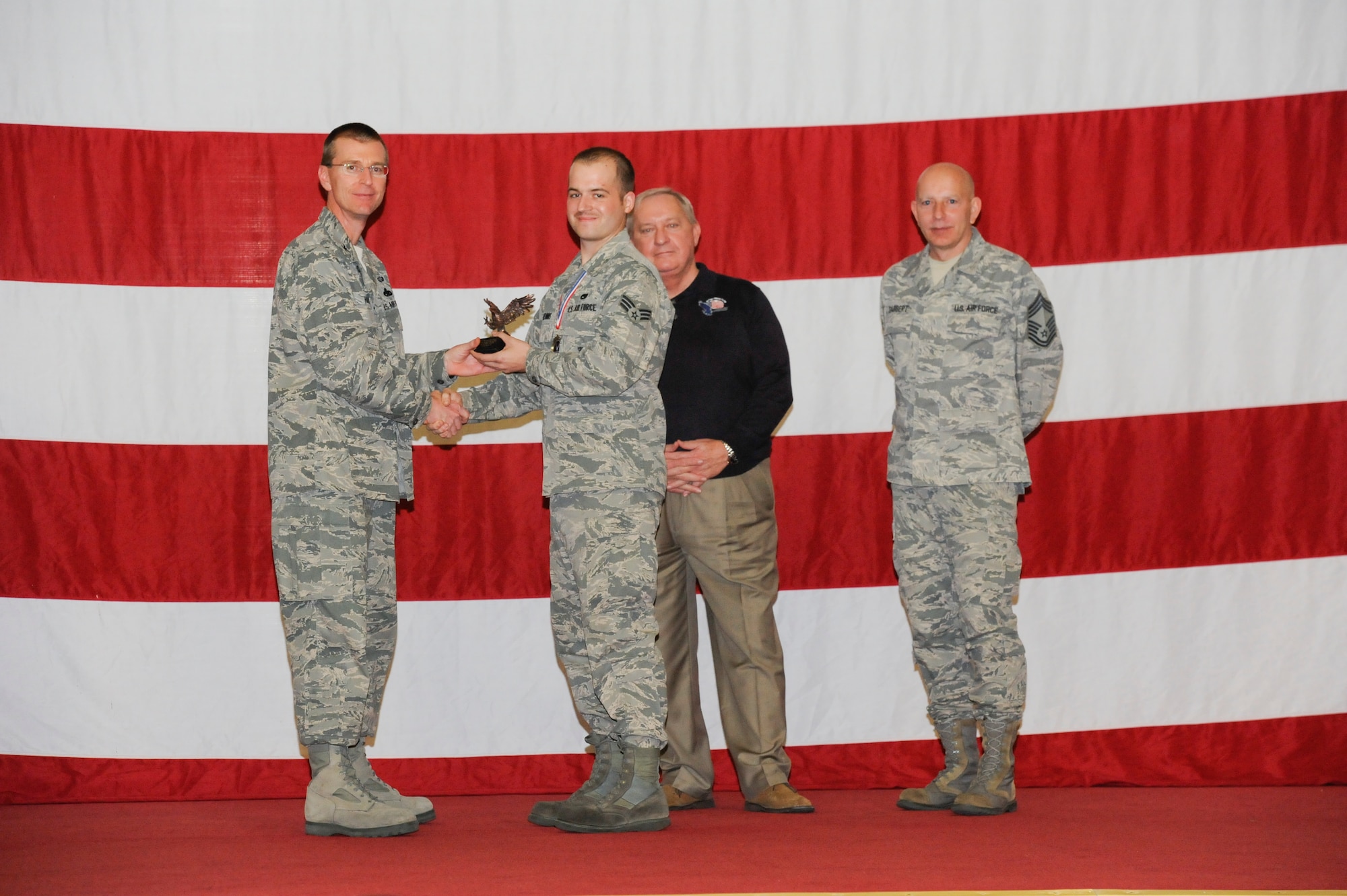 Senior Airman David Hennis receives the award for Maintenance Professional of the Year in the Airman category from Col. Curtis Hafer, 325th Maintenance Group commander, and Chief Master Sgt. Terry Gabbert, 325th MXG superintendent, and retired ninth Chief Master Sergeant of the Air Force, Chief Master Sgt. James Binnicker, during the 2012 Maintenance and Staff Professionals of the Year banquet in Hangar 1 March 15. The MPOY banquet recognizes the achievements of the maintenance group and honors maintenance professionals each year. (U.S. Air Force photo by Chris Cokeing)