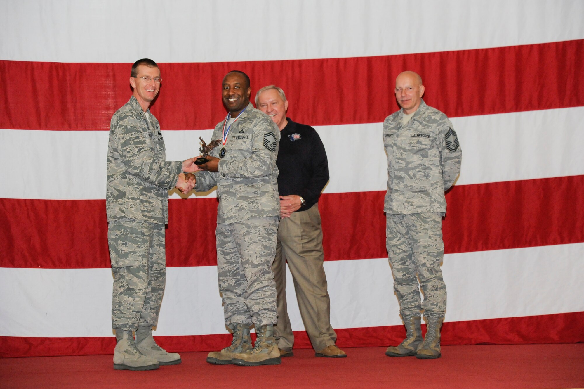 Senior Master Sgt. Dale. E. Goods, 325th Maintenance Operations Squadron, receives the award for the Staff Professional of the Year in the senior NCO category from Col. Curtis Hafer, 325th Maintenance Group commander, and Chief Master Sgt. Terry Gabbert, 325th MXG superintendent, and retired ninth Chief Master Sergeant of the Air Force, Chief Master Sgt. James Binnicker, during the 2012 Maintenance and Staff Professionals of the Year banquet in Hangar 1 March 15. The MPOY banquet recognizes the achievements of the maintenance group and honors maintenance professionals each year. (U.S. Air Force photo by Chris Cokeing)