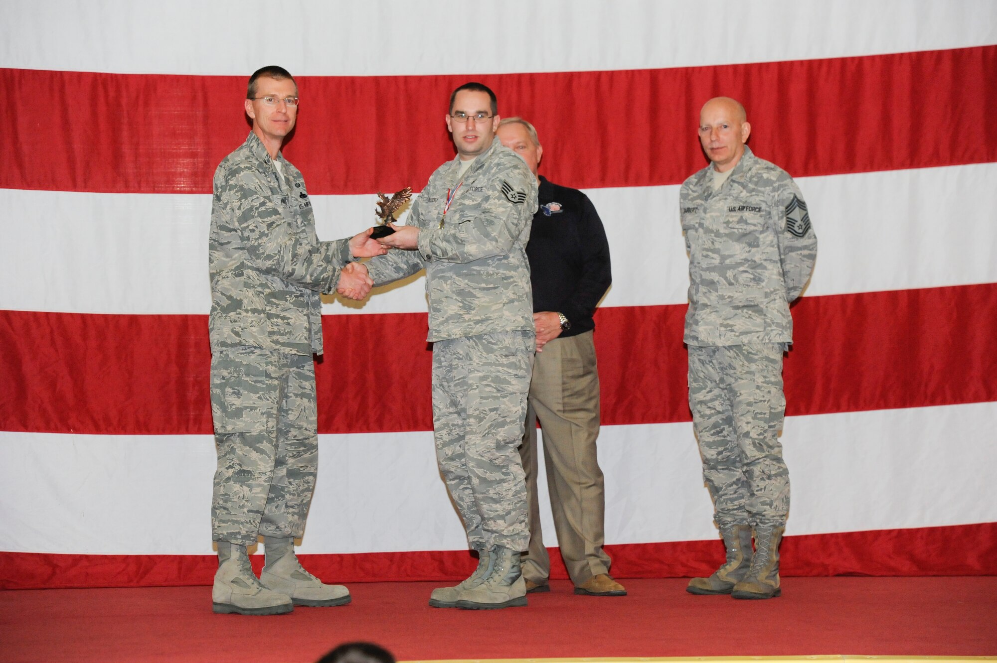 Staff Sgt. Travis Gregory, 325th Maintenance Operations Squadron, receives the award for the Staff Professional of the Year in the NCO category from Col. Curtis Hafer, 325th Maintenance Group commander, and Chief Master Sgt. Terry Gabbert, 325th MXG superintendent, and retired ninth Chief Master Sergeant of the Air Force, Chief Master Sgt. James Binnicker, during the 2012 Maintenance and Staff Professionals of the Year banquet in Hangar 1 March 15. The MPOY banquet recognizes the achievements of the maintenance group and honors maintenance professionals each year. (U.S. Air Force photo by Chris Cokeing)