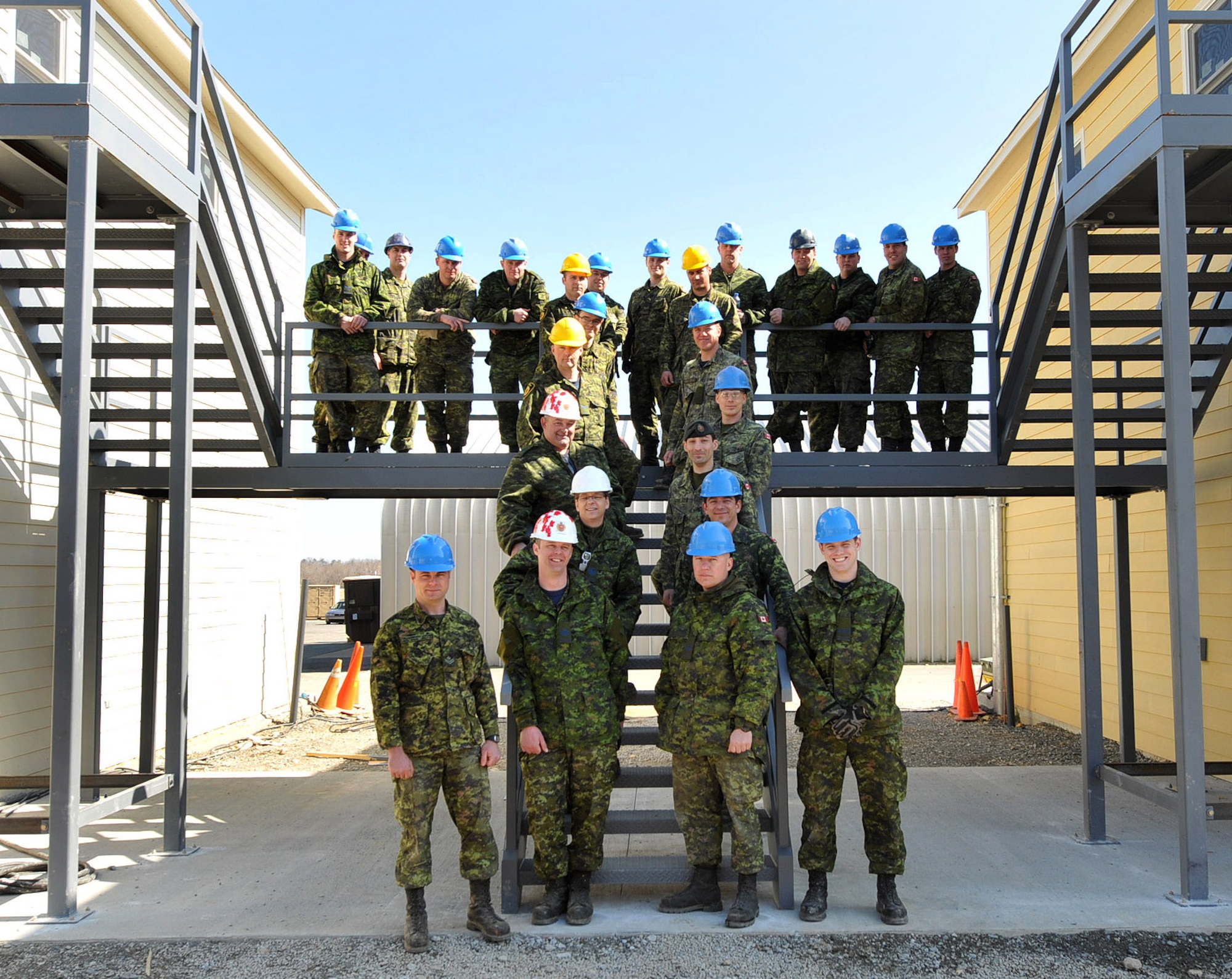 NEW LONDON,   N.C.  – In March 2013, 26 members of the Royal Air Force 3 Wing Construction Engineers Canadian Forces from Bagotville, Quebec, take time out for a photo on stairs installed between two buildings they constructed to be used for sleeping quarters and classrooms.  The Canadians were at the North Carolina Air National Guard Regional Training Site in New London, N.C., participating in the Deployment for Training Program hosted by 145th Civil Engineering Squadron.  This program is an exchange agreement between the Royal Canadian Air Force and the United States Air National Guard.  (National Guard Photo by Tech. Sgt. Patricia Findley, 145th Public Affairs) 

