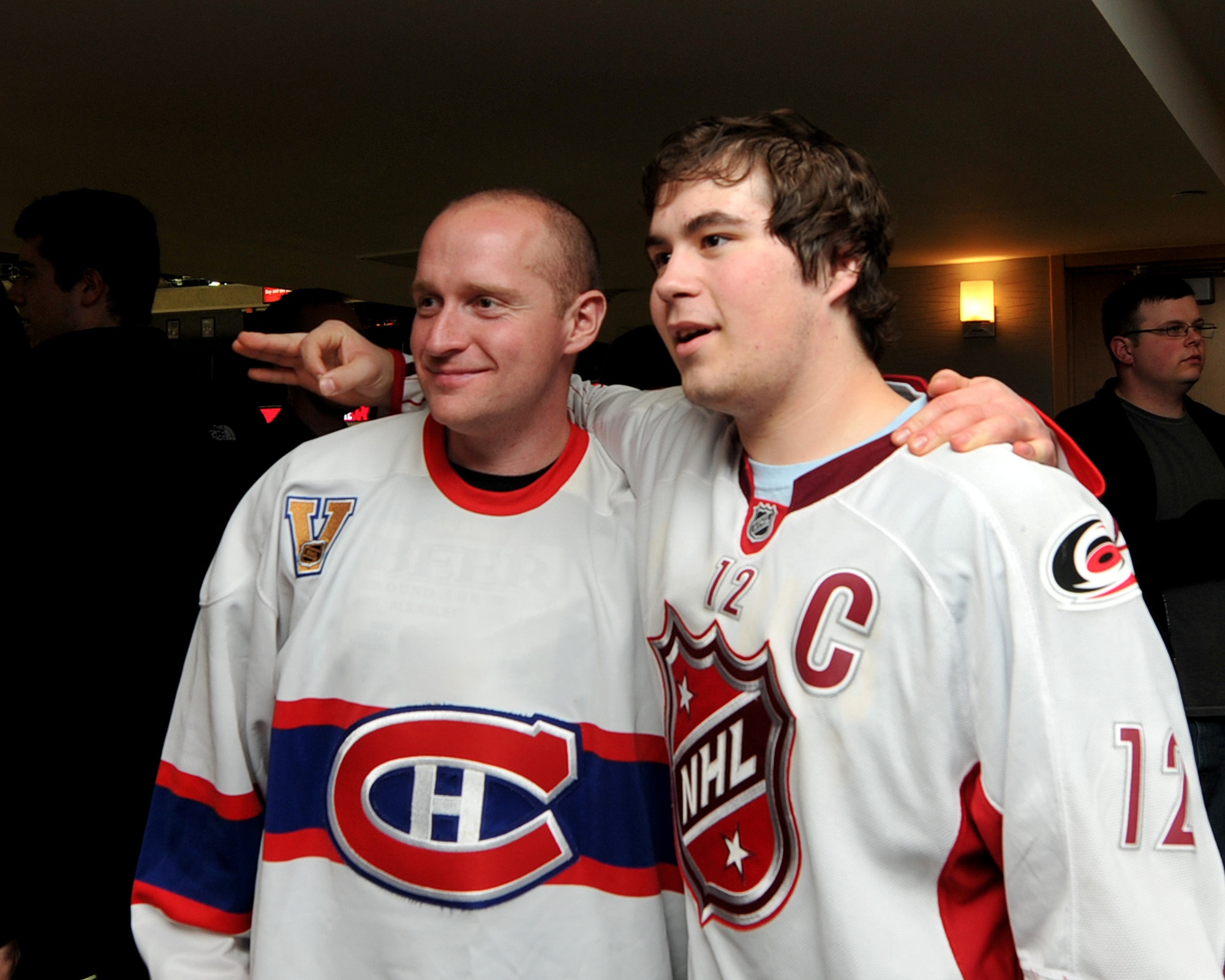 RALEIGH, N.C. – March 7, 2013, CPL. Jonathan St-Louis, Royal Air Force 3 Wing Construction Engineers Canadian Forces, Bagotville, Quebec, pose with a student from Sanderson High School while attending Hurricanes vs. Montréal Canadians NHL game. For two weeks 26, 3 Wing Construction Engineers participated in the Deployment for Training Program, an exchange agreement between the Royal Canadian Air Force and the United States Air National Guard hosted by 145th Civil Engineering Squadron at the North Carolina Air National Guard Regional Training Site in New London, N.C.  Canadian and 145th CE members were honored guest of The Centennial Authority of Raleigh.  (National Guard Photo by Tech. Sgt. Patricia Findley, 145th Public Affairs)