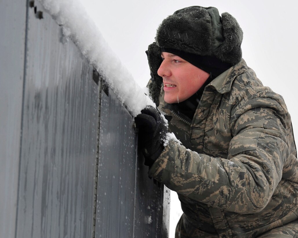 Tech. Sgt. Matthew Cain, 459th Aircraft Maintenance Squadron crew chief, dusts snow off a generator March 25, 2013 at Joint Base Andrews, Md. Despite the spring snowfall, which is forecasted to bring up to five inches of snow to the area, JBA service members must still perform their mission essential duties. (U.S. Air Force photo/Airman 1st Class Erin O’Shea)    