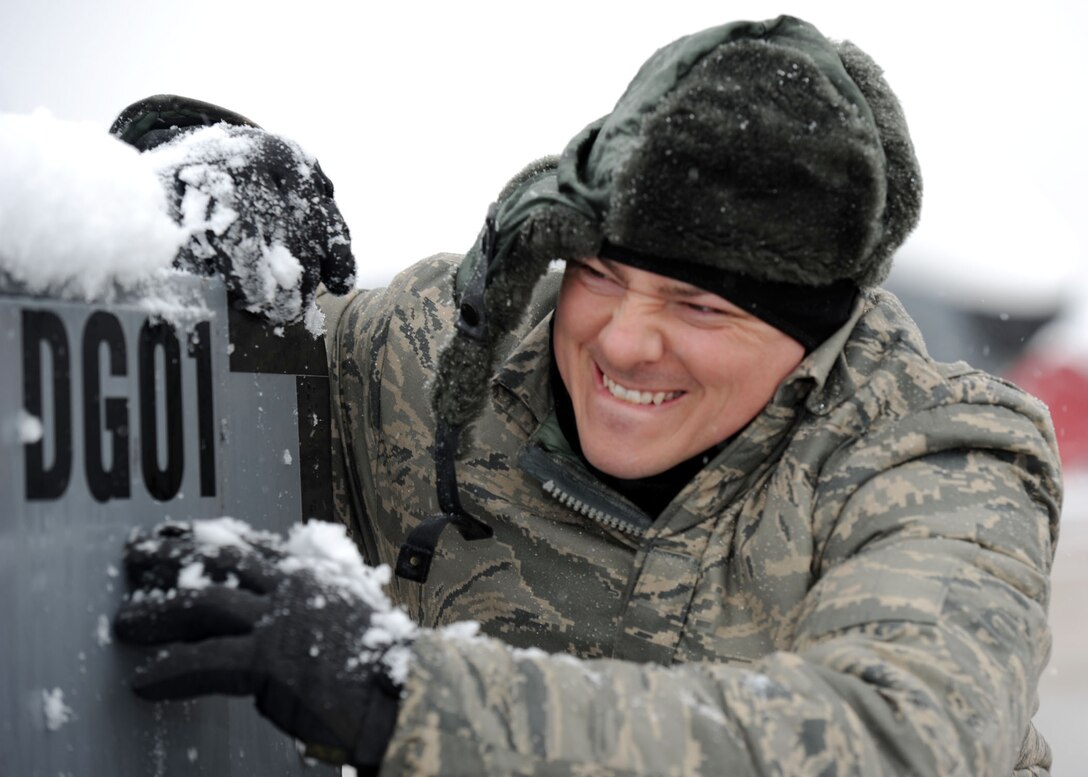 Sgt. Matthew Cain, 459th Aircraft Maintenance Squadron crew chief, dusts snow off of a generator before conducting pre-flight checks on a KC-135 Stratotanker at Joint Base Andrews, Md., March 25, 2013. The spring snowstorm is forecasted to bring up to five inches of snow to the local area. (U.S. Air Force photo/Staff Sgt. Nichelle Anderson)
