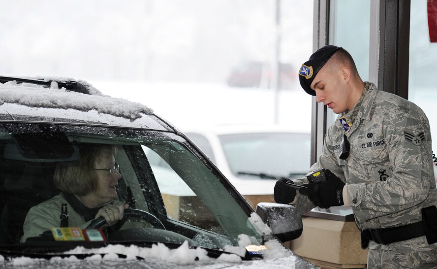 Senior Airman Journey Henderson, 11th Security Force Squadron elite guard, checks identification cards as people enter Joint Base Andrews, Md., March 25, 2013. Defenders continue security operations despite a spring snowstorm forecasted to bring up to five inches of snow to the area. (U.S. Air Force photo/Staff Sgt. Nichelle Anderson)