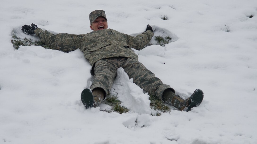 Airman 1st Class Lindsay Helbig, U.S. Air Force Honor Guard, ceremonial guardsman assigned to 11th Wing Protocol makes a snow angel outside of the Jones Building Mar. 25, 2013 at Joint Base Andrews, Md. Up to five inches of snow fell at JBA, marking the first major snowstorm of the year for the area. (U.S. Air Force photo/Staff Sgt. Perry Aston)