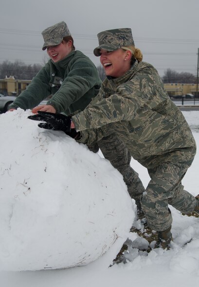 Airman 1st Class Lindsay Helbig, U.S. Air Force Honor Guard, ceremonial guardsman assigned to 11th Wing Protocol and Senior Airman Lauren Main, 11th Wing Public Affairs photojournalist make a snowman Mar. 25, 2013 at Joint Base Andrews, Md. Up to five inches of snow fell at JBA, marking the first major snowstorm of the year for the area. (U.S. Air Force photo/Staff Sgt. Perry Aston)