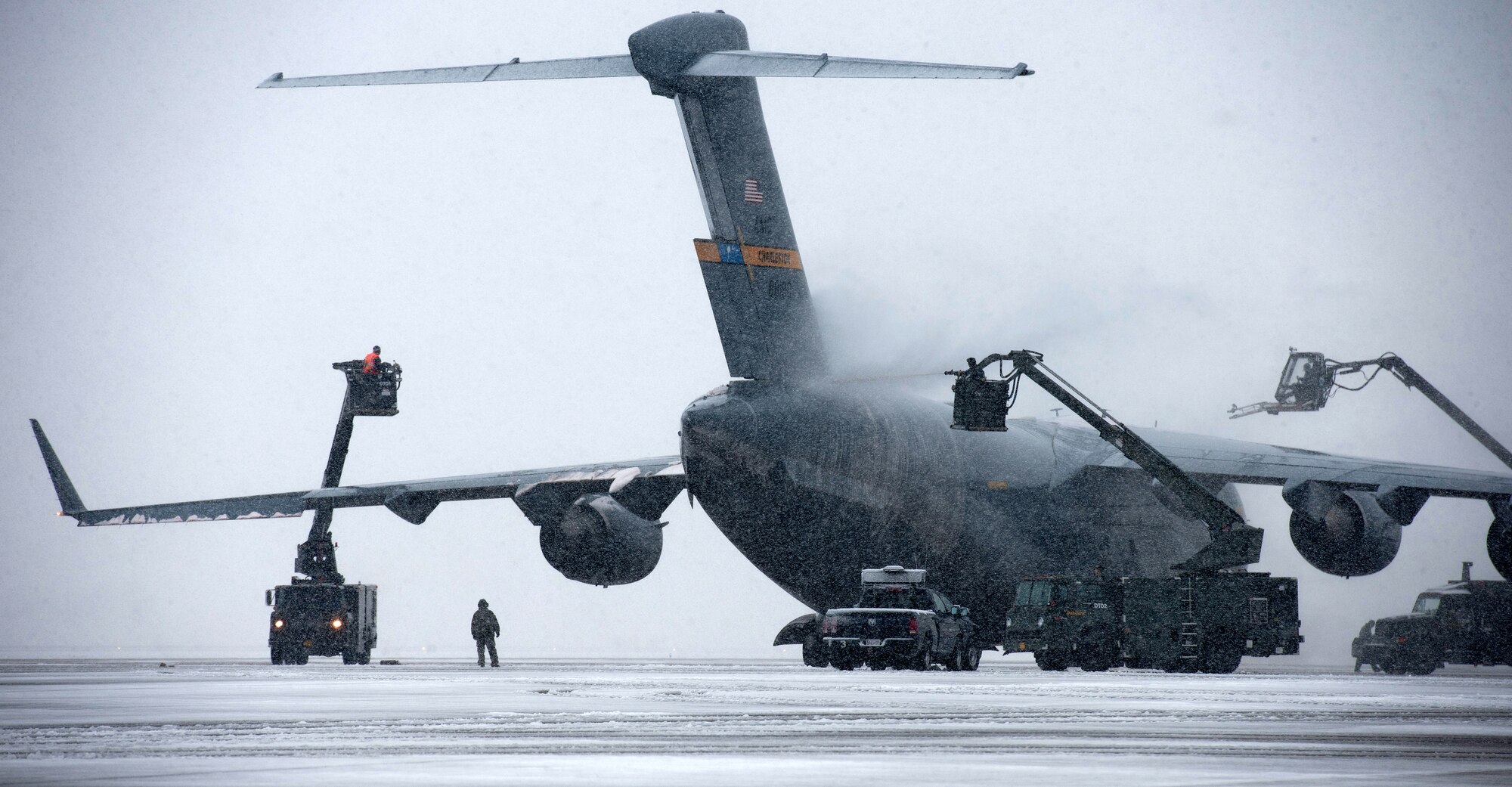 De-icers remove snow and ice from a Joint Base Charleston C-17 Globemaster III from Mar. 25, 2013 at Joint Base Andrews, Md. Up to five inches of snow fell at JBA, marking the first major snowstorm of the year for the area.(U.S. Air Force photo/Staff Sgt. Perry Aston)