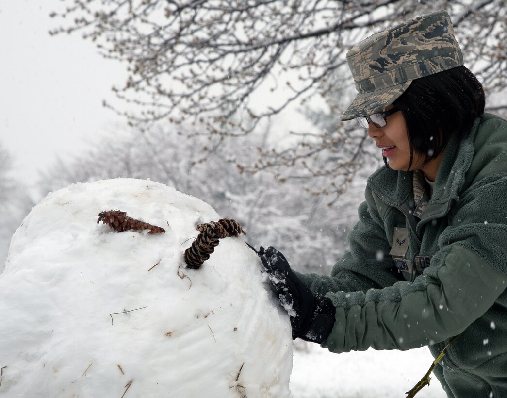 Airman 1st Class Hayley Teehera, Joint Base Andrews Honor Guard makes a snow man outside the honor guard building. March 25, 2013 at Joint Base Andrews, Md. Up to five inches of snow fell at JBA, marking the first major snowstorm of the year for the area.(U.S. Air Force photo/Staff Sgt. Perry Aston)