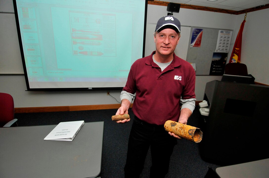 During a class on UXO identification for AEDC’s firefighters and security police officers, Jim Miller, the UXO safety officer for EA Engineering, Corp., holds two inert shell casings, in his right hand is a 37 mm armor-piercing round, and the one in his left hand is an expended 75 mm shrapnel round. He showed the class other UXOs and munitions remnants that can be found in what was once Camp Forrest’s munitions ranges on Arnold Air Force Base. (Photo by Rick Goodfriend)